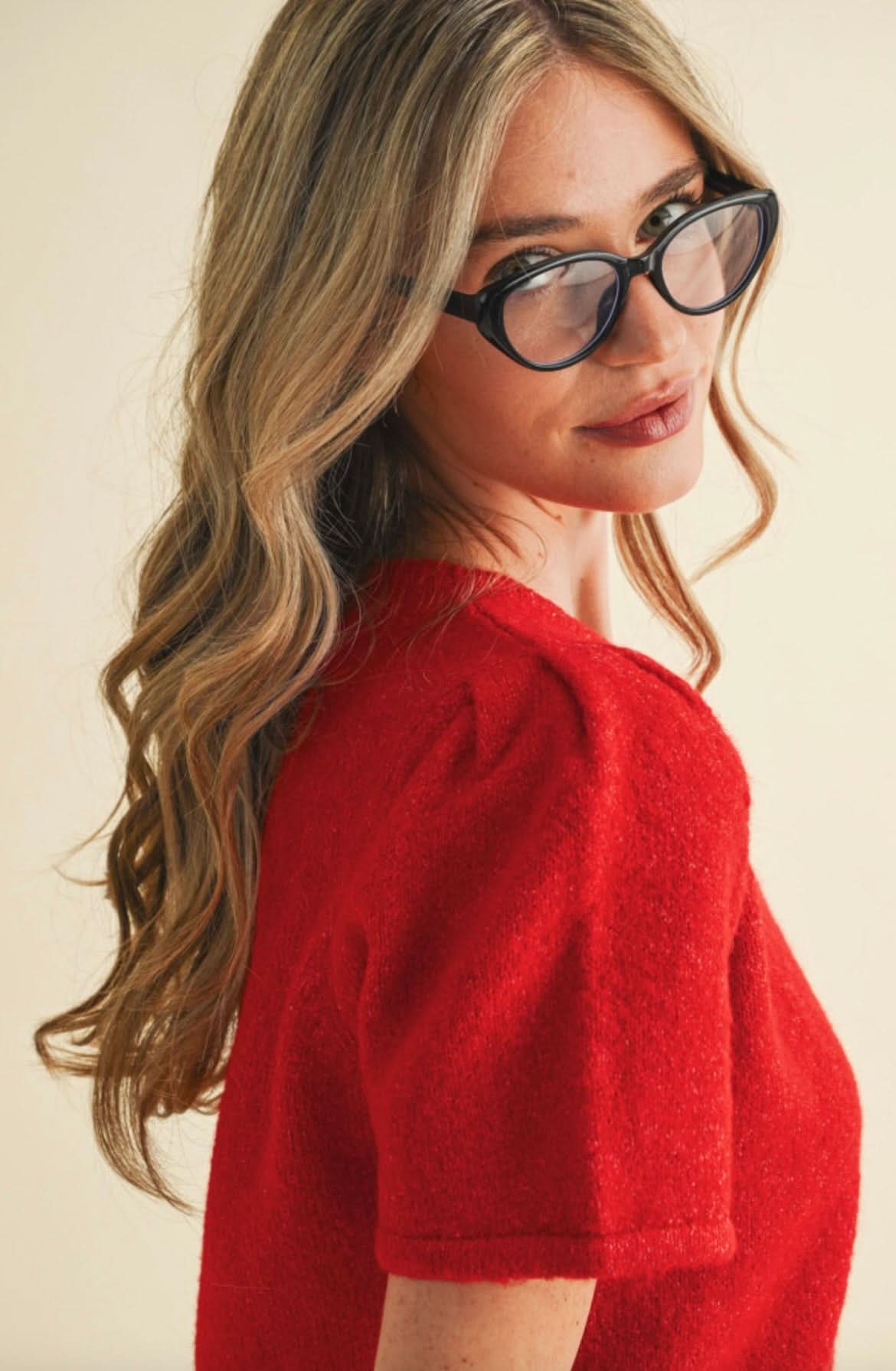 Woman wearing red, fuzzy, short sleeved, button up cardigan