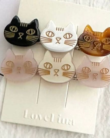 A pair of three colorful cats on a clip in a pack of two behind a white and purple background.