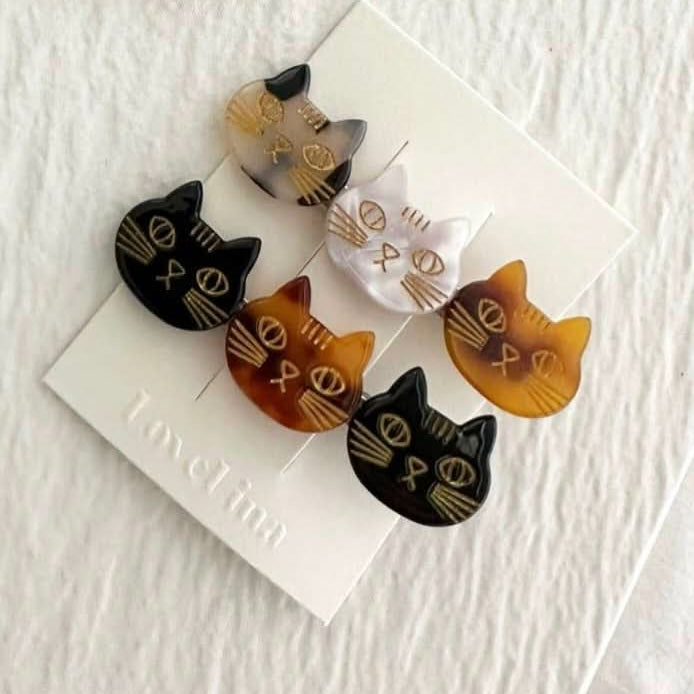 A pair of three colorful cats on a clip in a pack of two behind a white background.