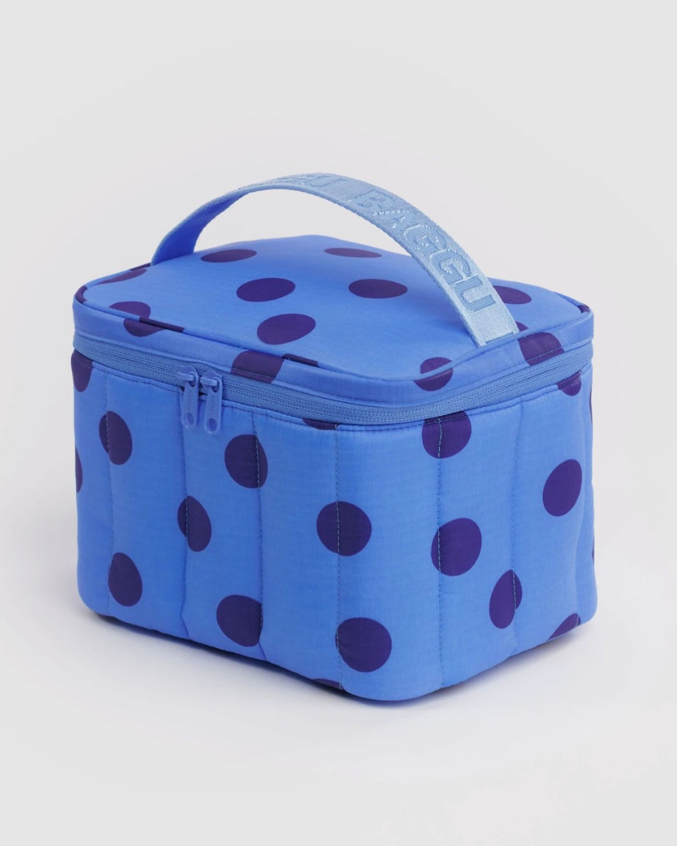 A blue quilted lunch bag with dark purple polka dots and a light blue top handle featuring the brand name 'RAGGU' in white.