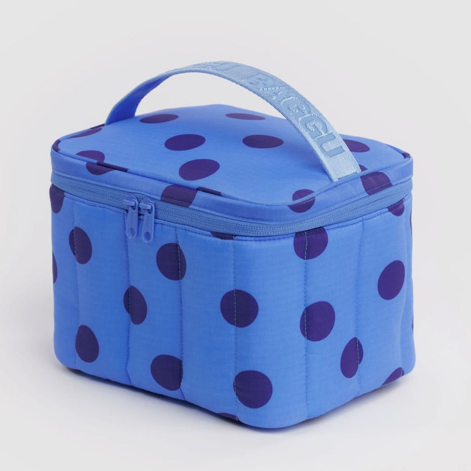 A blue quilted lunch bag with dark purple polka dots and a light blue top handle featuring the brand name 'RAGGU' in white.