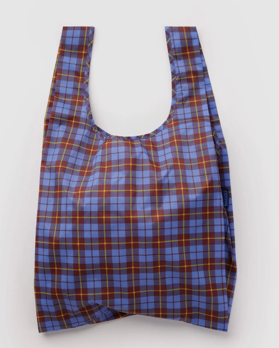 A reusable plastic shopping bag with a blue, brown, and yellow plaid pattern, shown against a plain light gray background.