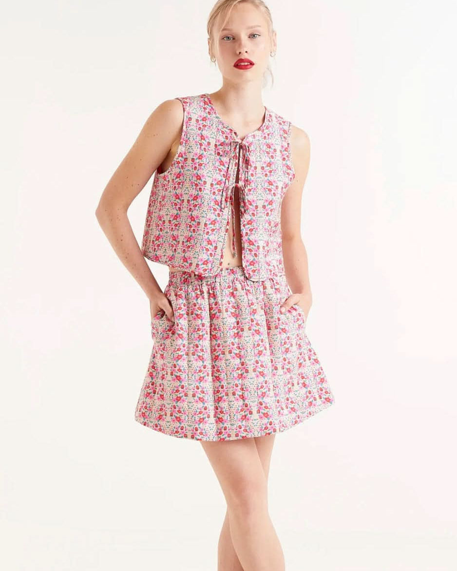 Woman wearing strawberry and floral collared ruffle sleeve button up skirt and matching top