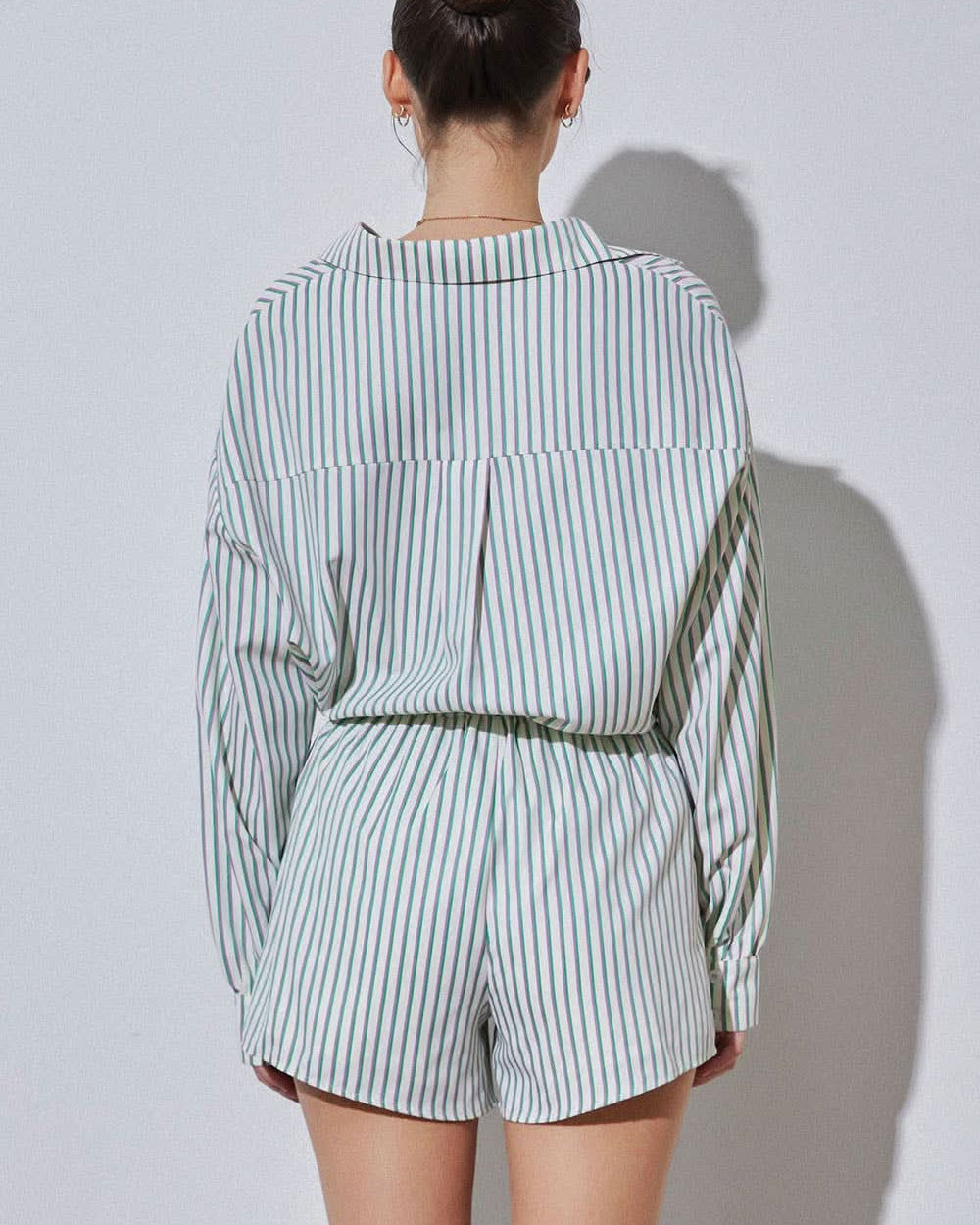 Woman wearing vertically striped green purple and blue set