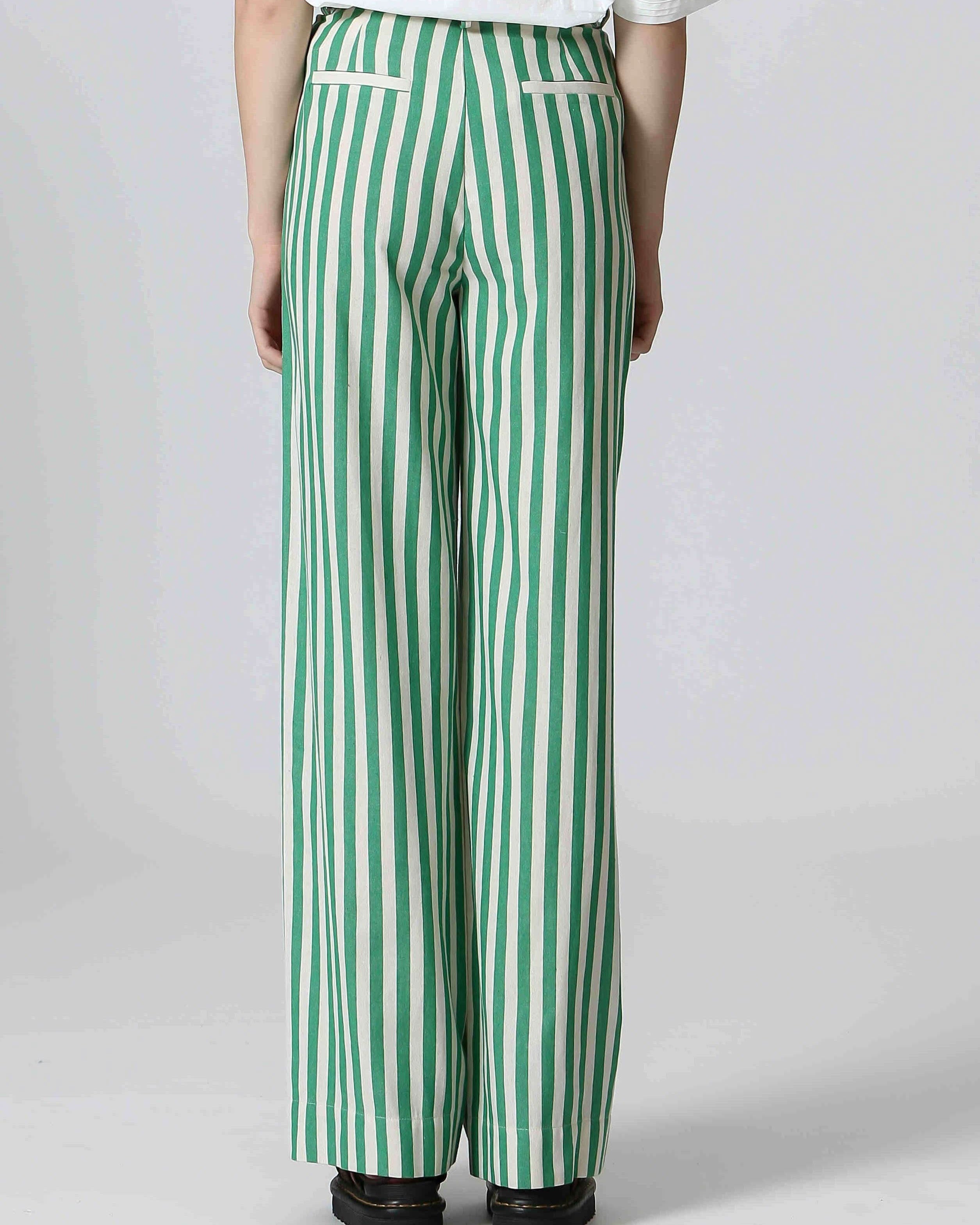 Woman wearing white shirt and green and white, vertically cotton striped pants