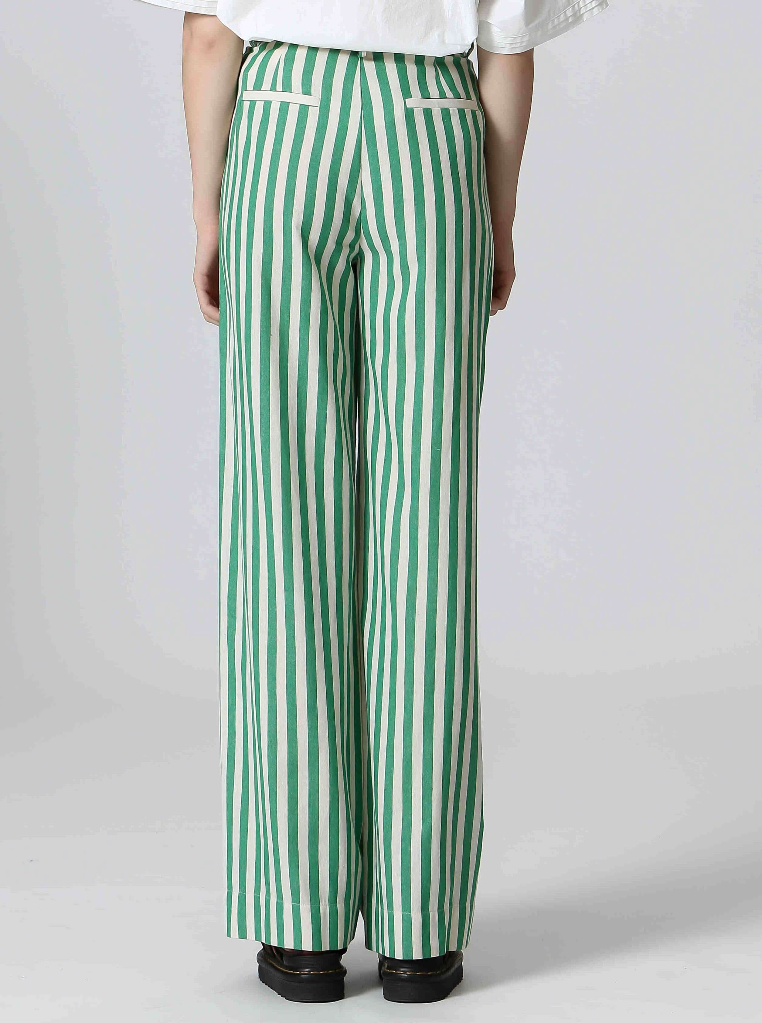 Woman wearing white shirt and green and white, vertically cotton striped pants