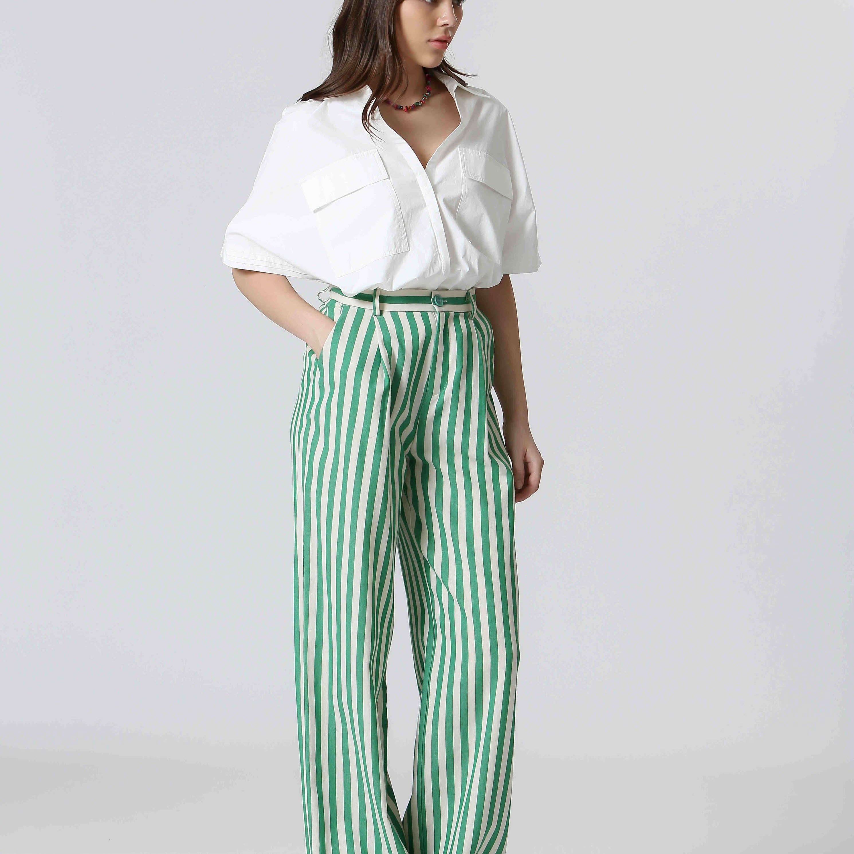 Woman wearing white shirt and green and white, vertically striped pants