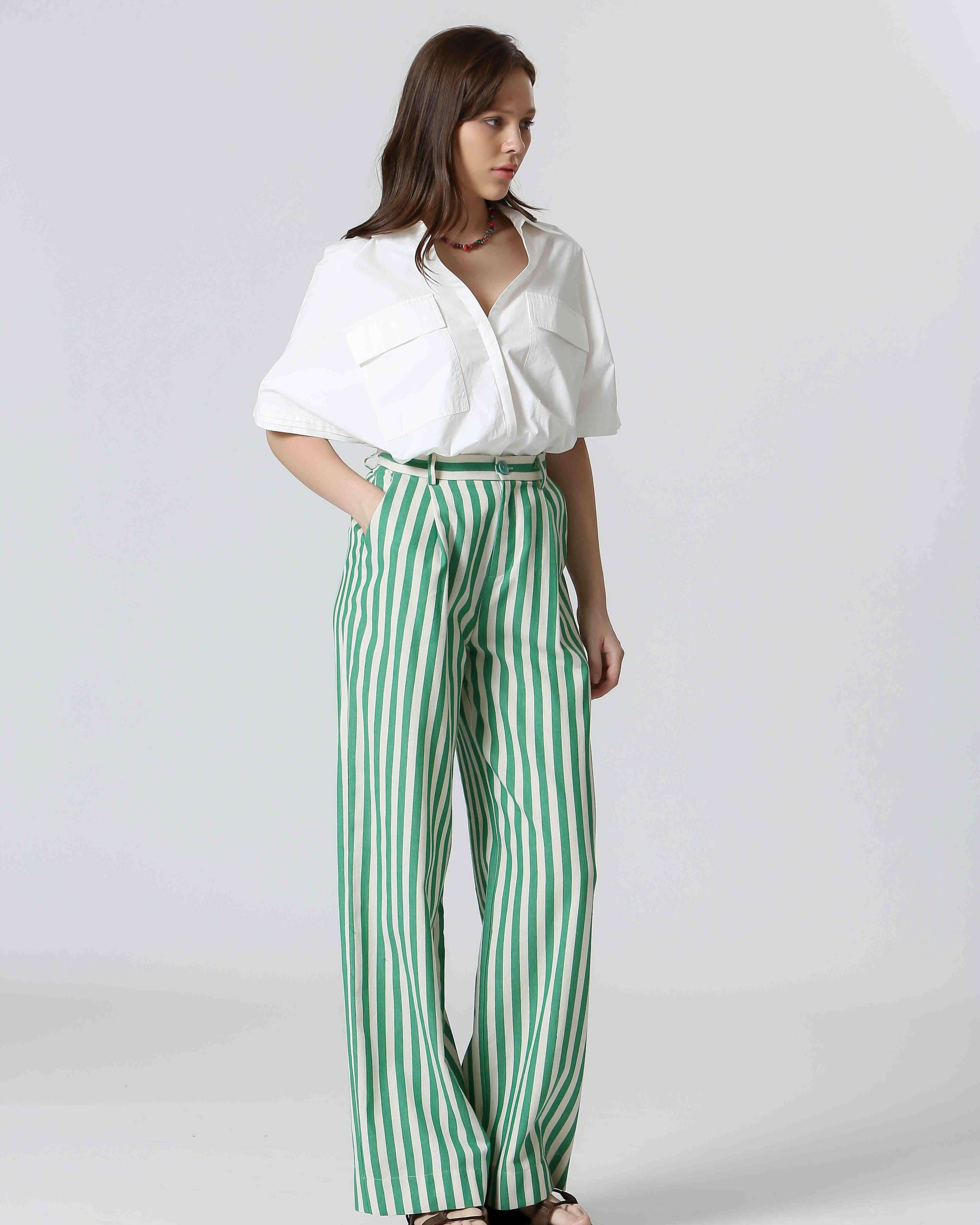 Woman wearing white shirt and green and white, vertically striped pants