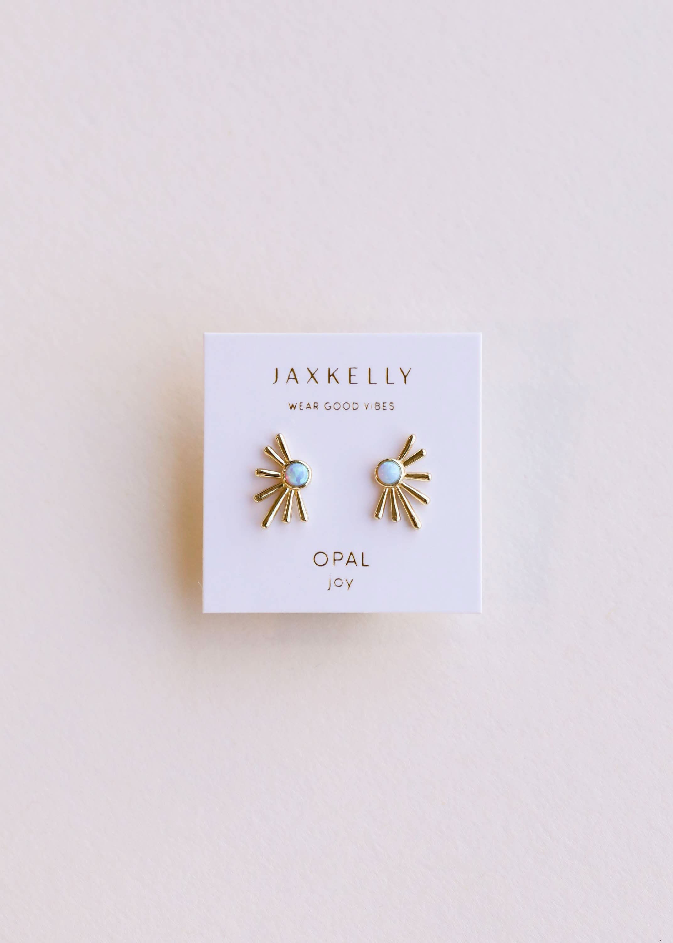 Jaxkelly opal earrings on a white card with a light pink background