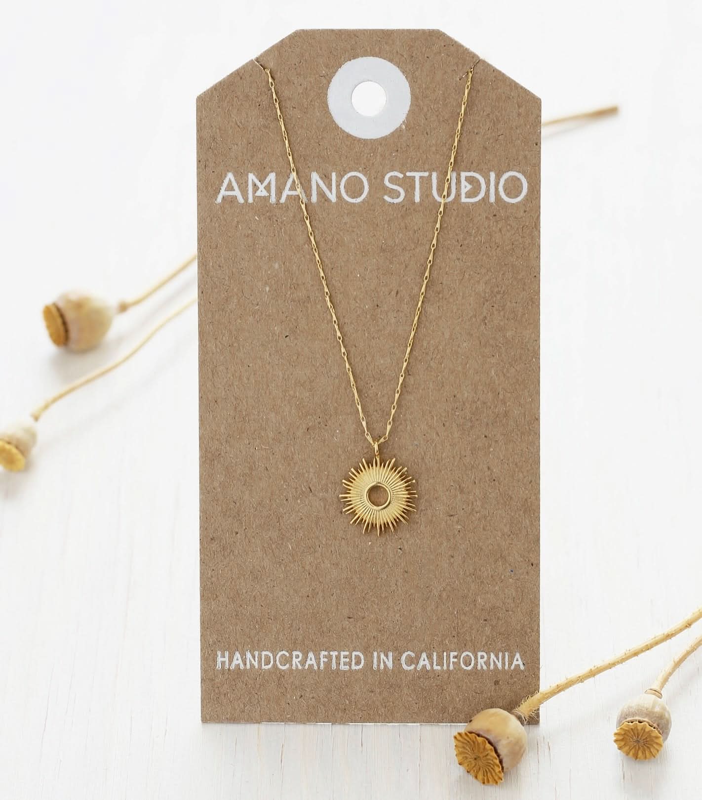 Gold necklace on a 'Amano Studio' branded card