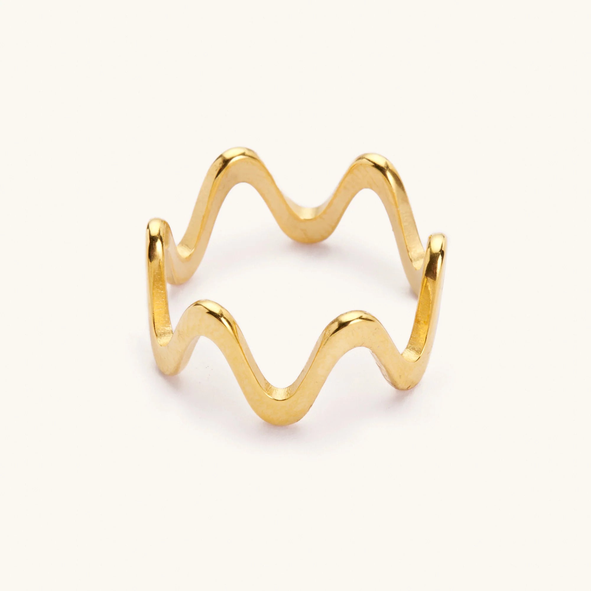 Gold wavy ring laying on a white background
