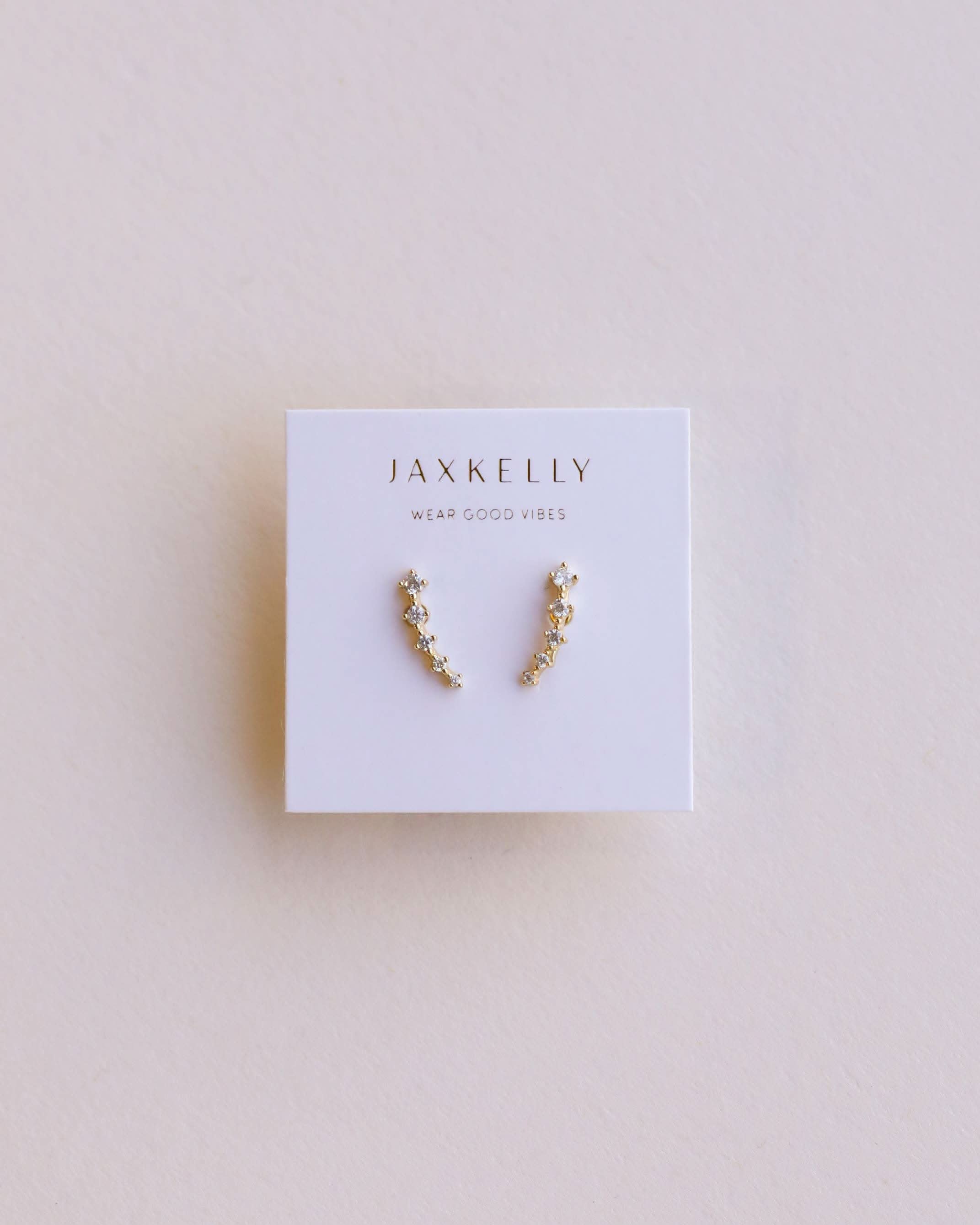 Pair of gold earrings on a Jaxkelly branded card