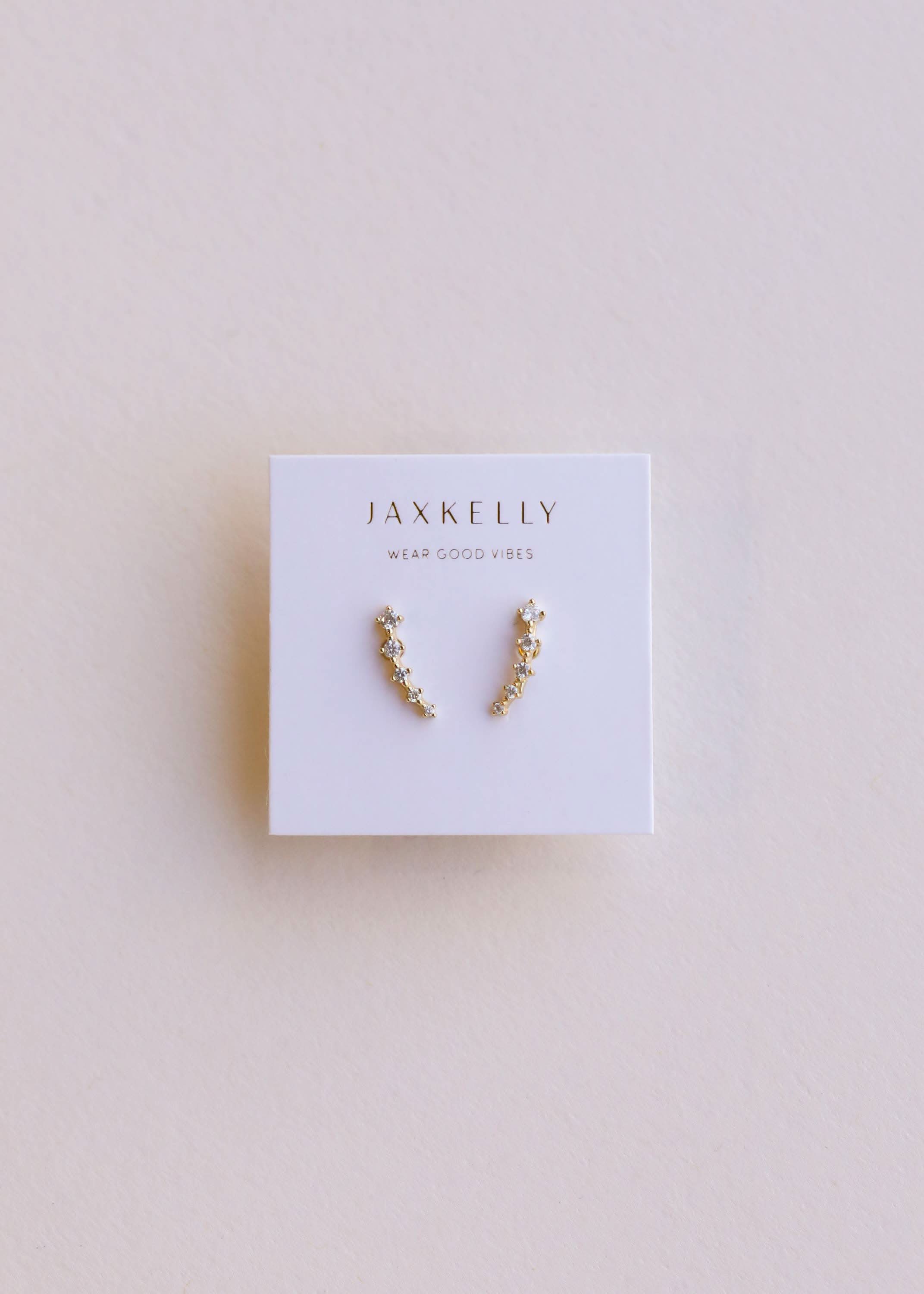 Pair of gold earrings on a Jaxkelly branded card
