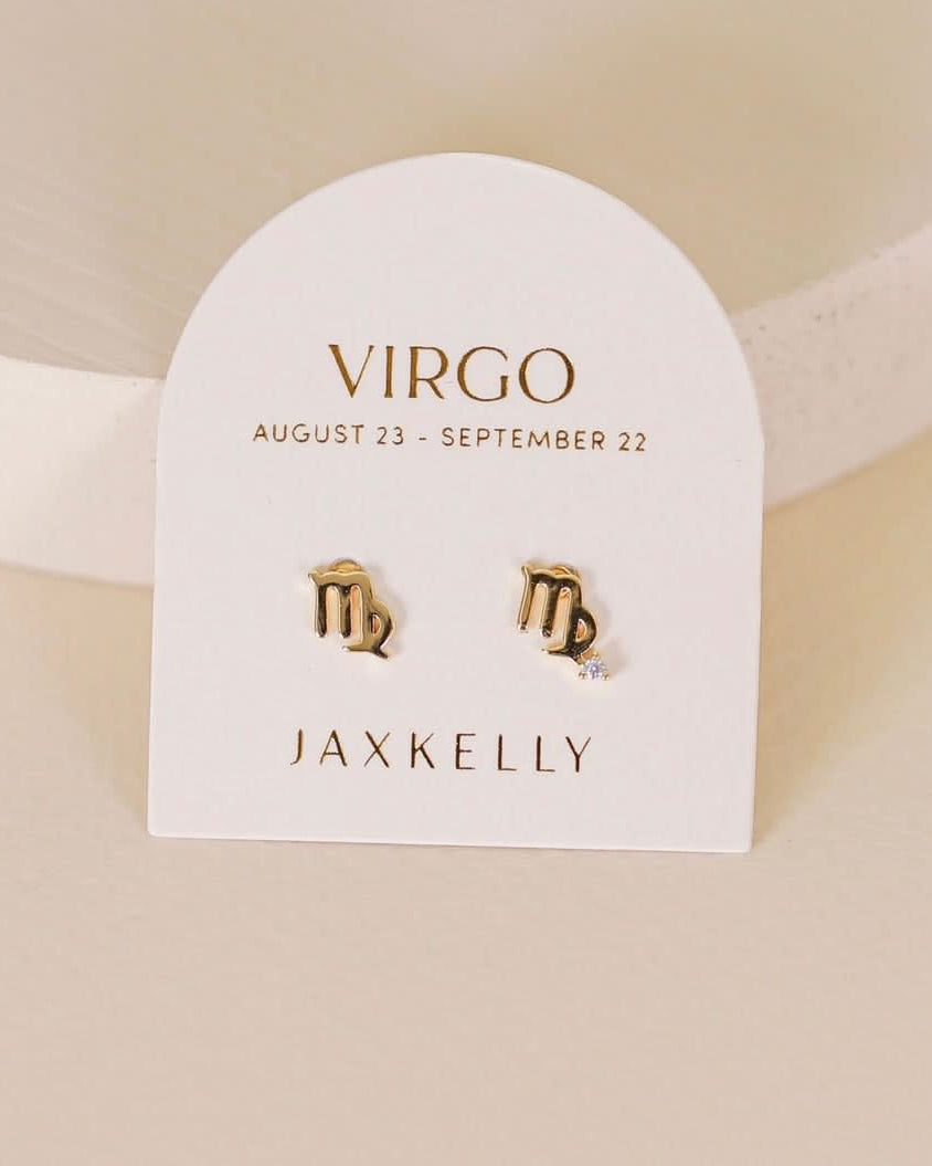 Gold zodiac charm studs in the shape of Virgo astrological sign displayed on earring card