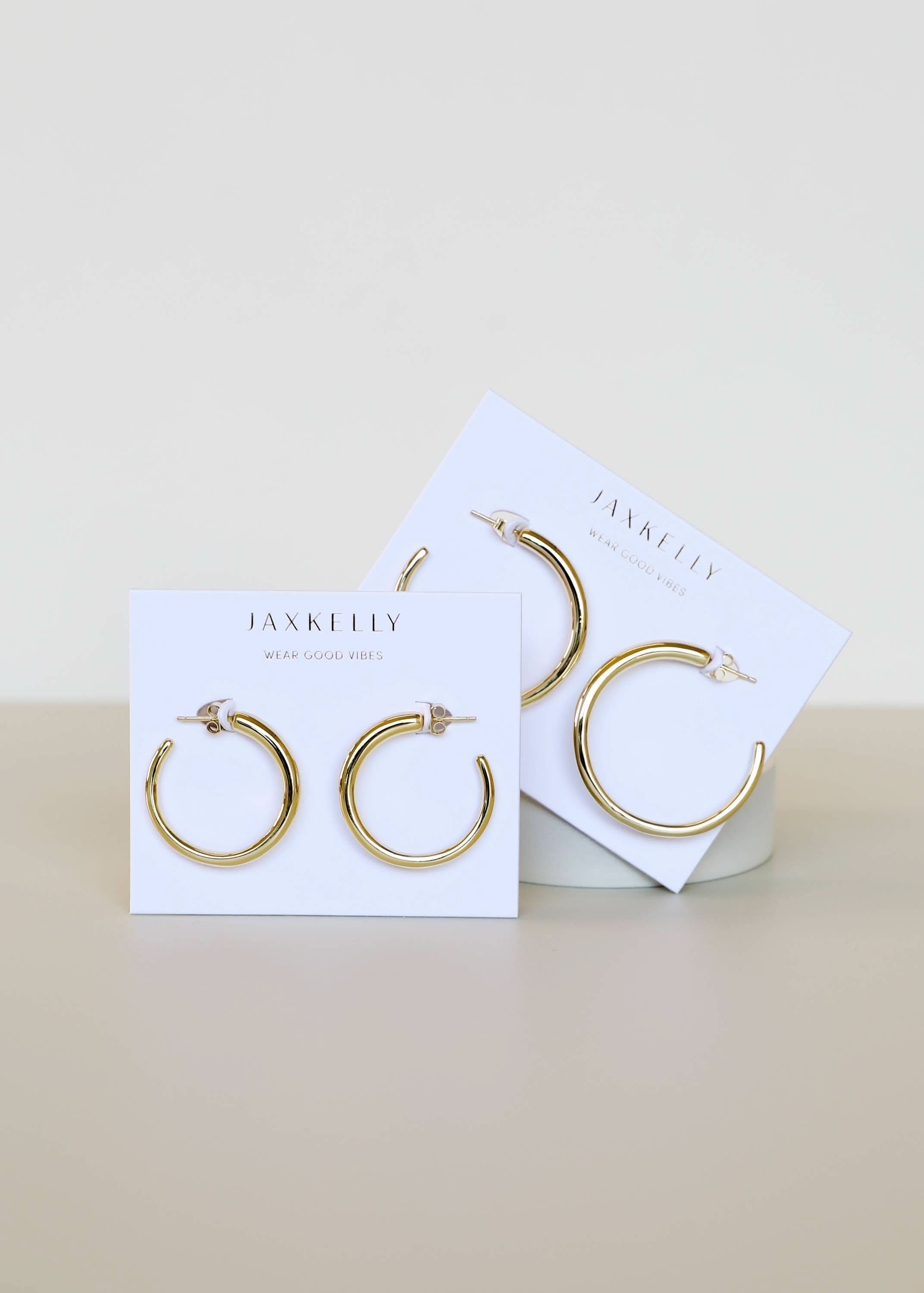 Gold hoop earrings on Jax Kelley branded cards against a white background