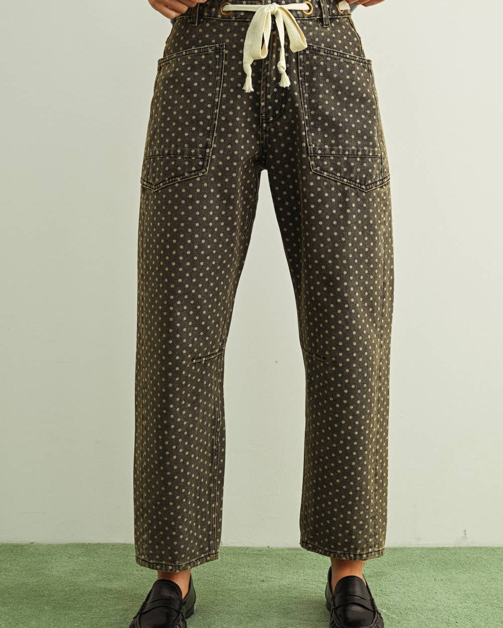 Person wearing patterned pants with a plain background