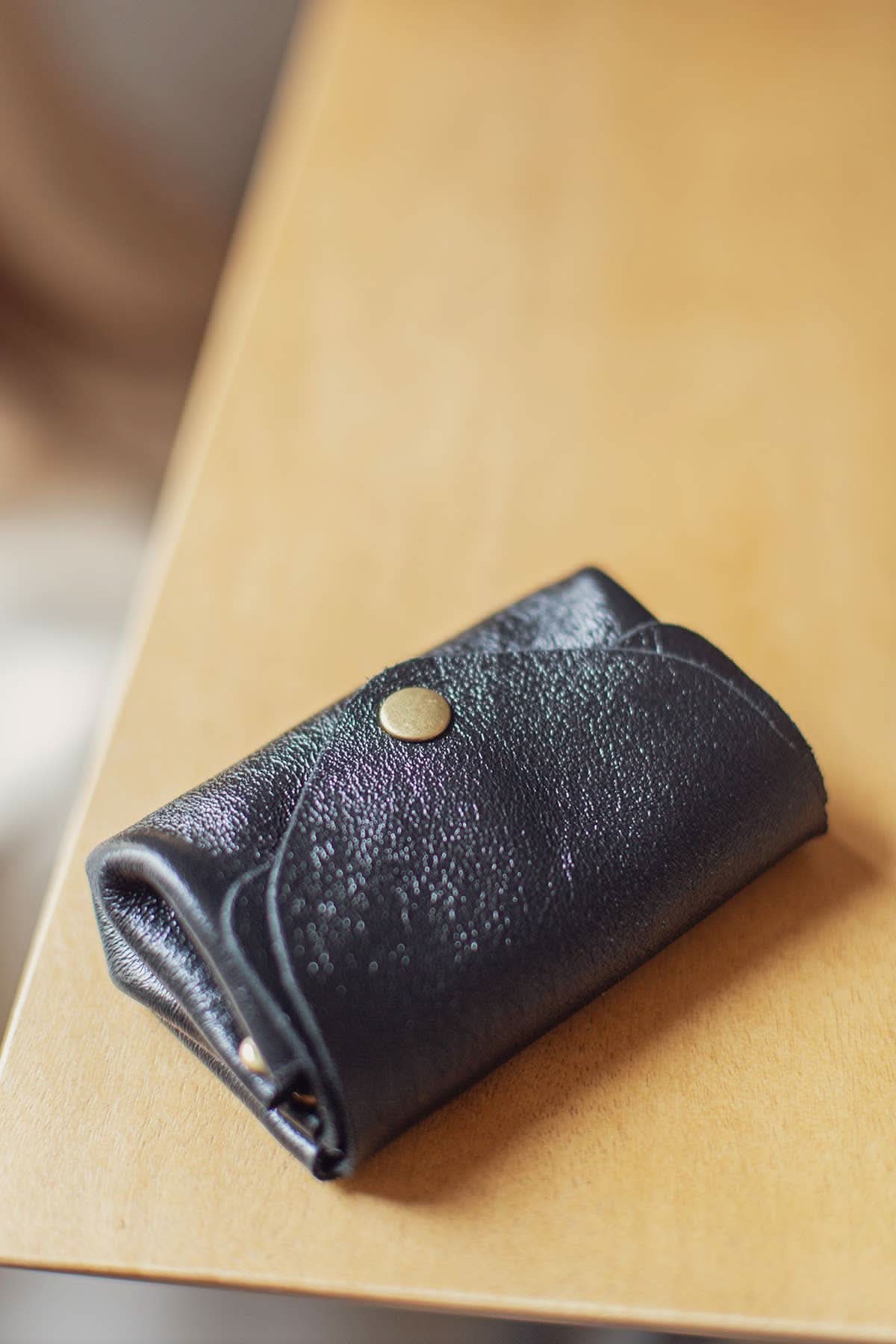 Small black Metal leather wallet with over flap and gold button clasp