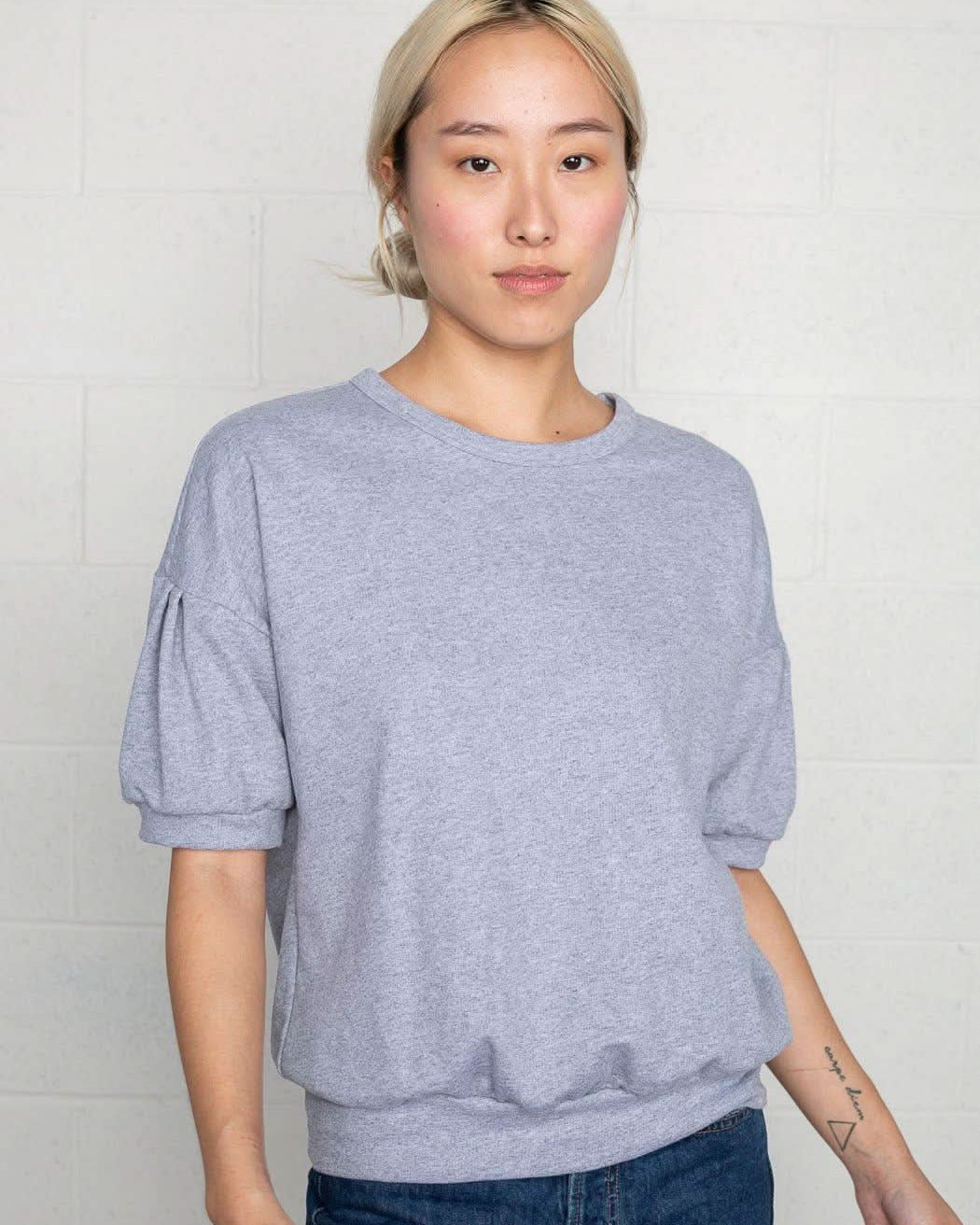 Woman wearing natural grey, short sleeve, puff sleeve, blouse t-shirt top