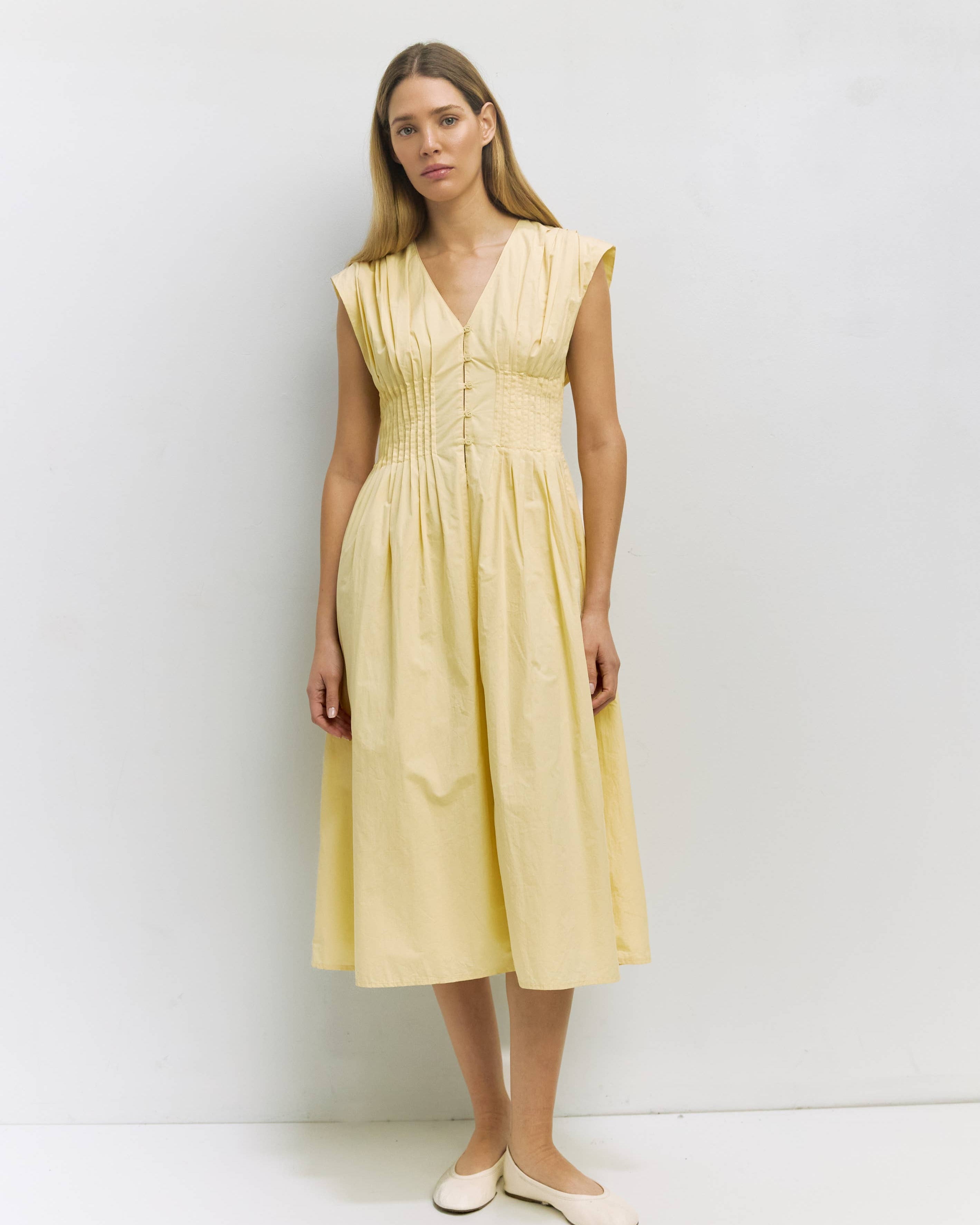 Woman wearing a yellow dress against a white background