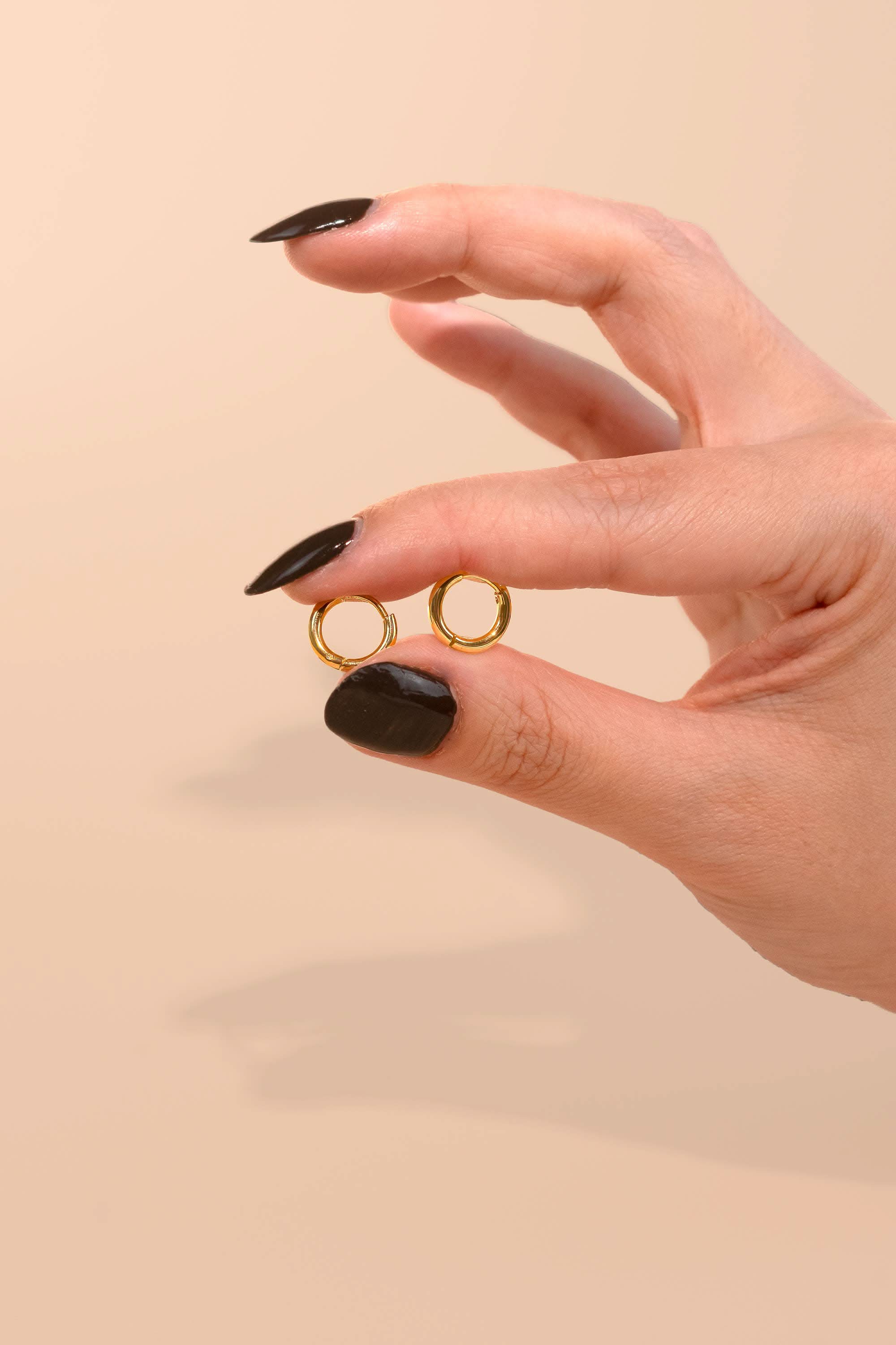 Hand hook ding pair on small huggie gold hoop earrings