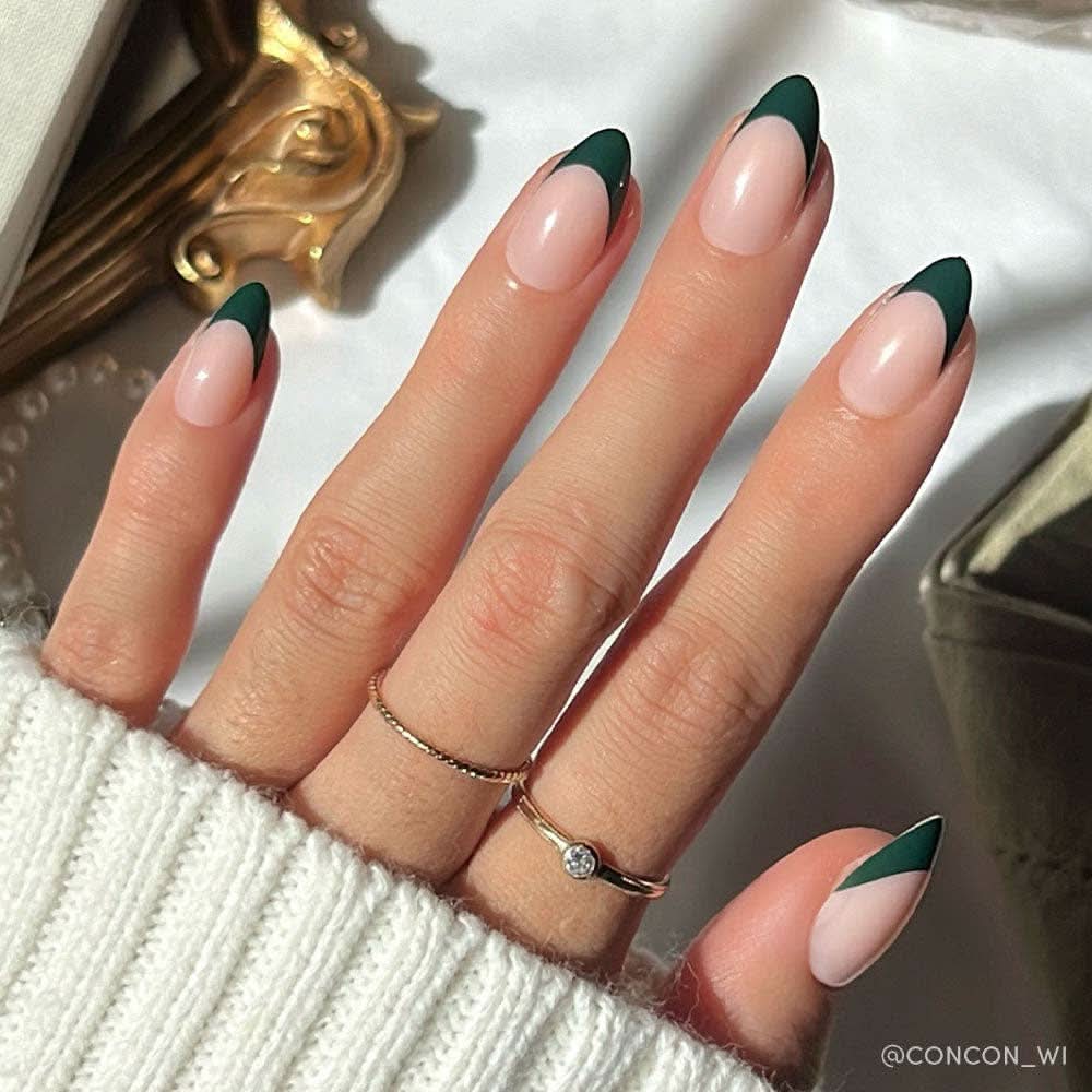 Short almond-shaped press-on nails with dark green French tips on semi-transparent base