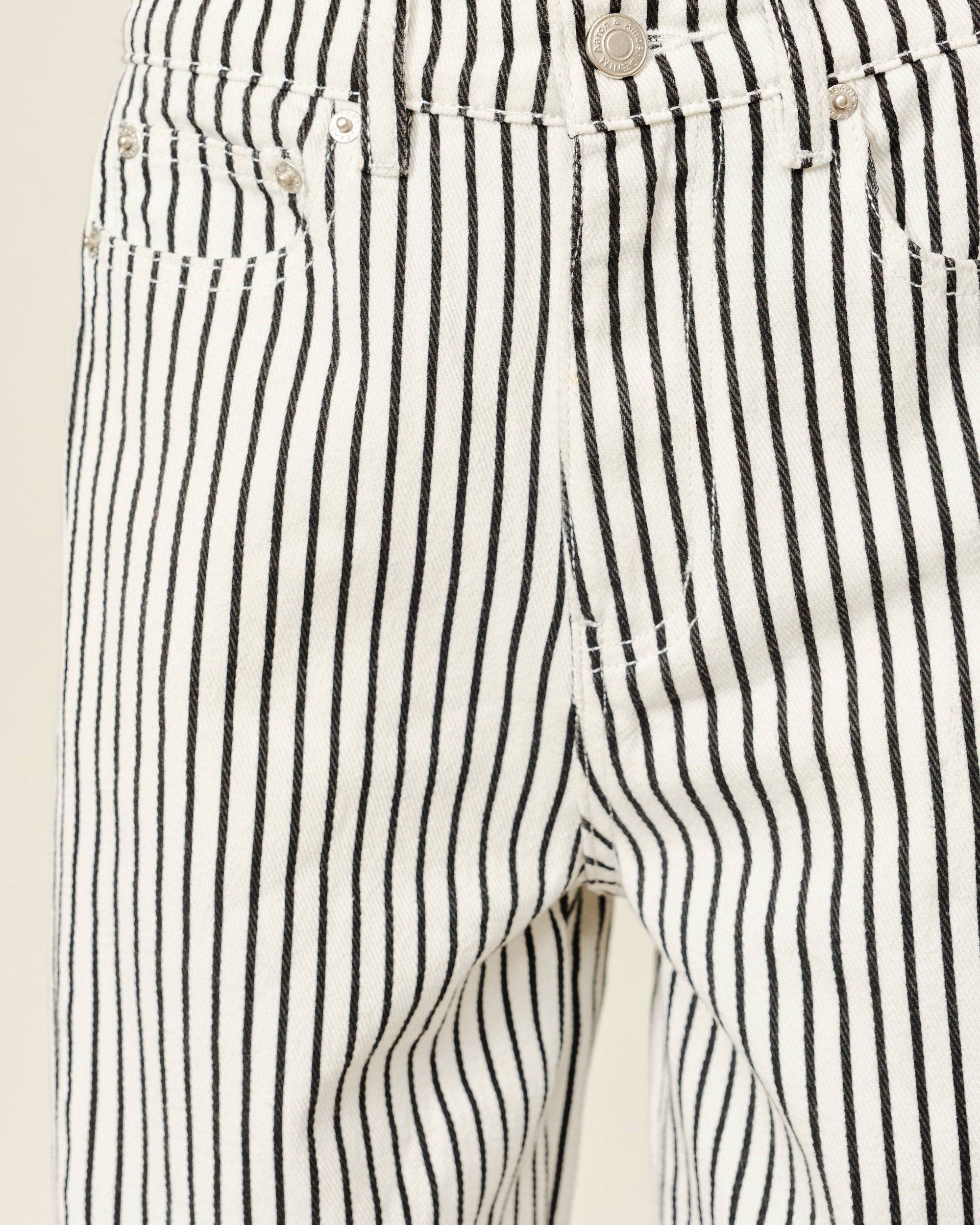Close-up of black and white striped pants with a beige background