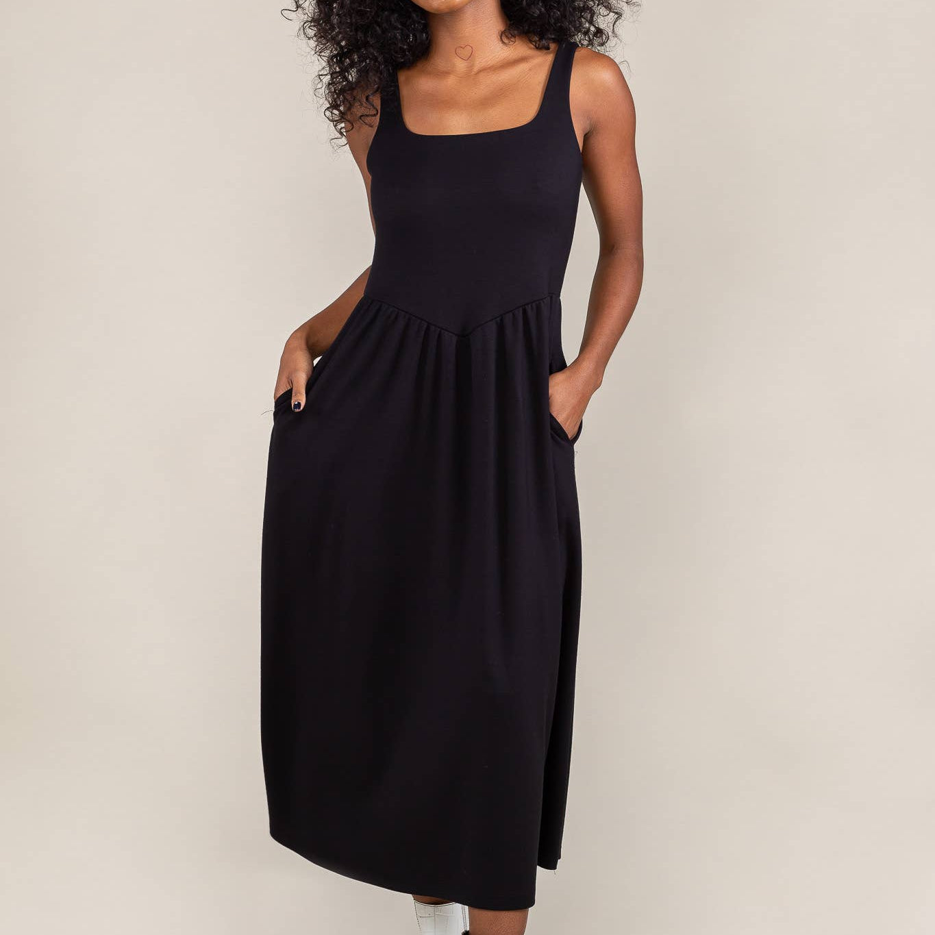 Woman wearing black colored, midi dress, with corset bodice detail