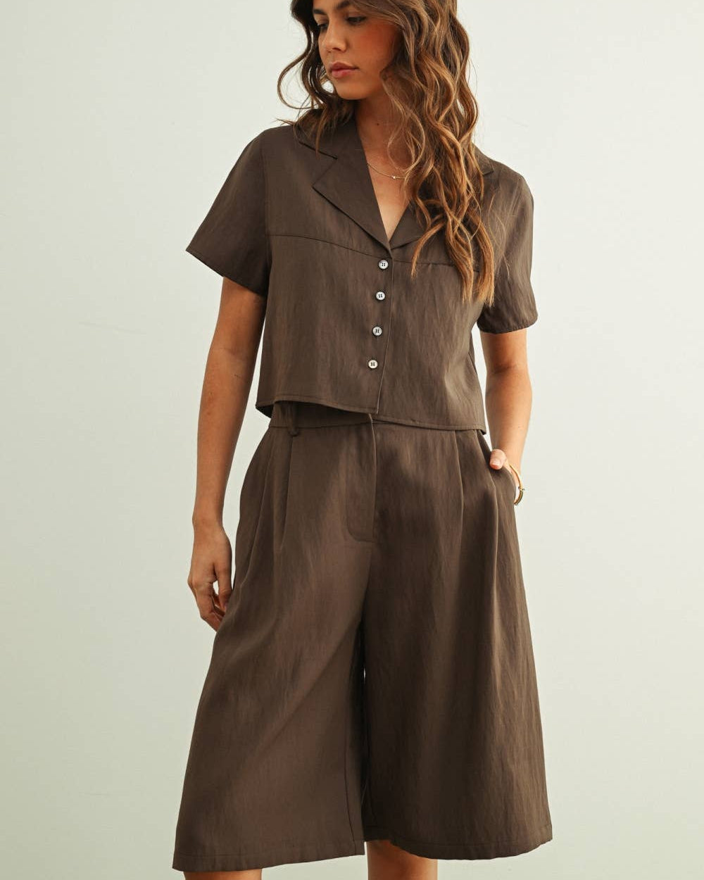 Woman wearing a brown outfit with a plain background