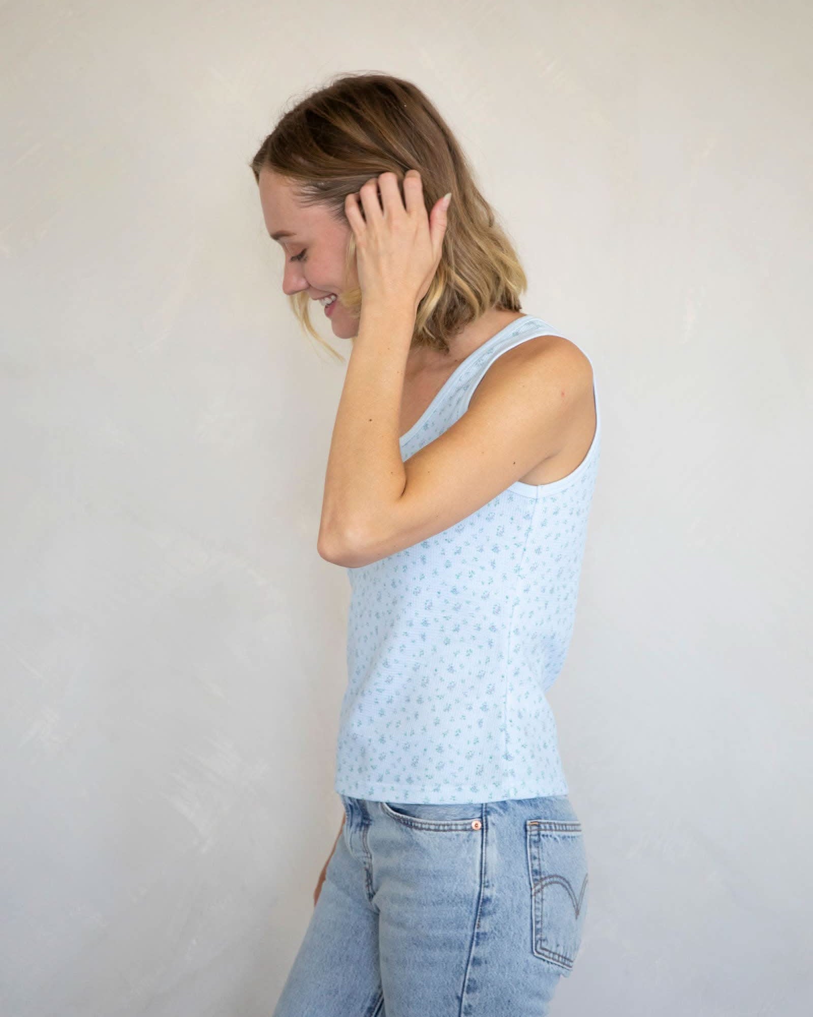 Woman wearing Waffle-knit henley tank top with a floral design in baby blue with blue jeans