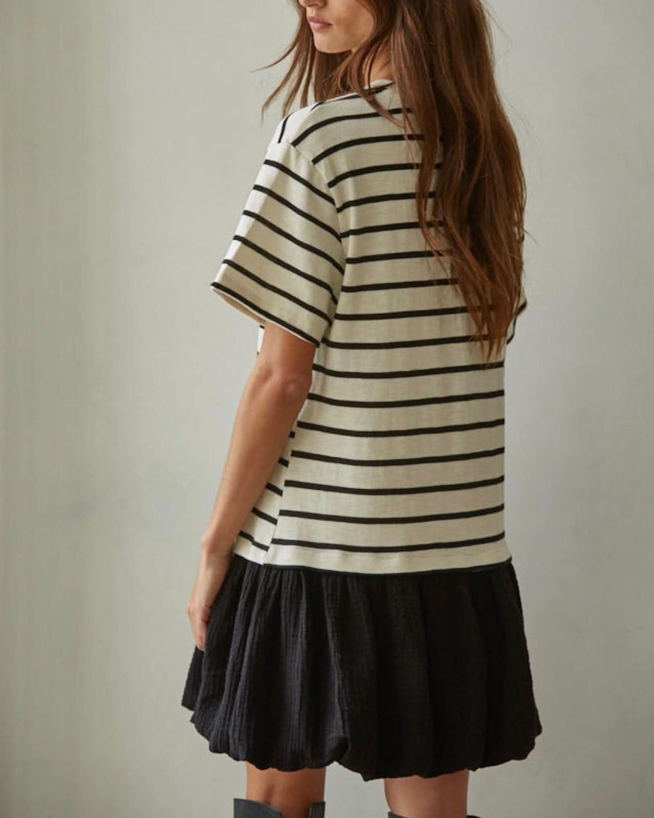 Woman wearing a striped shirt and black skirt back side