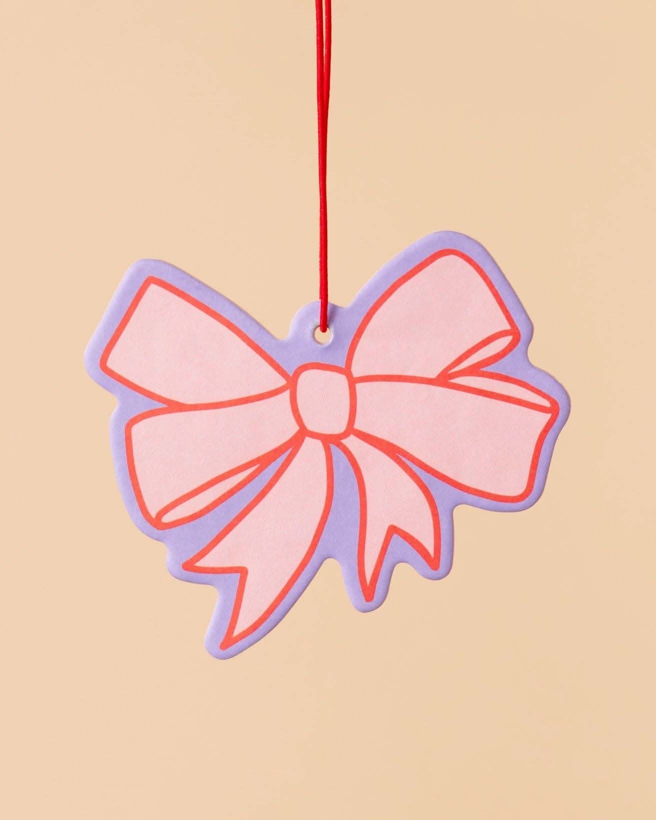 pink car air freshener with lavender and red detail