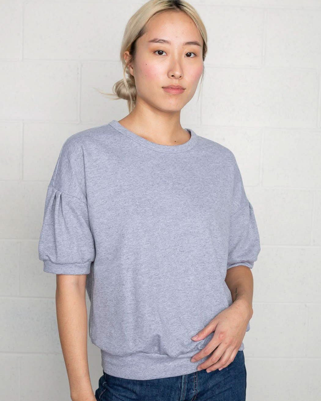 Woman wearing natural grey, short sleeve, puff sleeve, blouse t-shirt top
