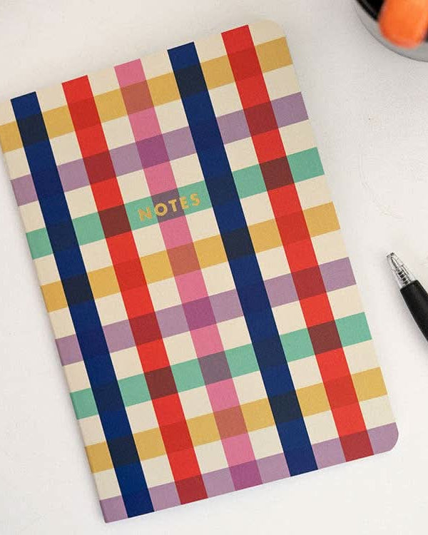Colorful plaid notebook with the word “notes” in gold print