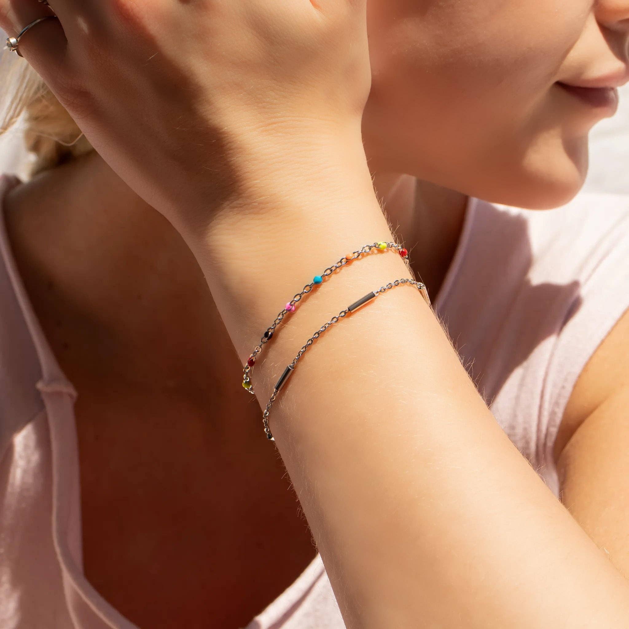 Close-up of a person wearing colorful beaded bracelets on a blurred background