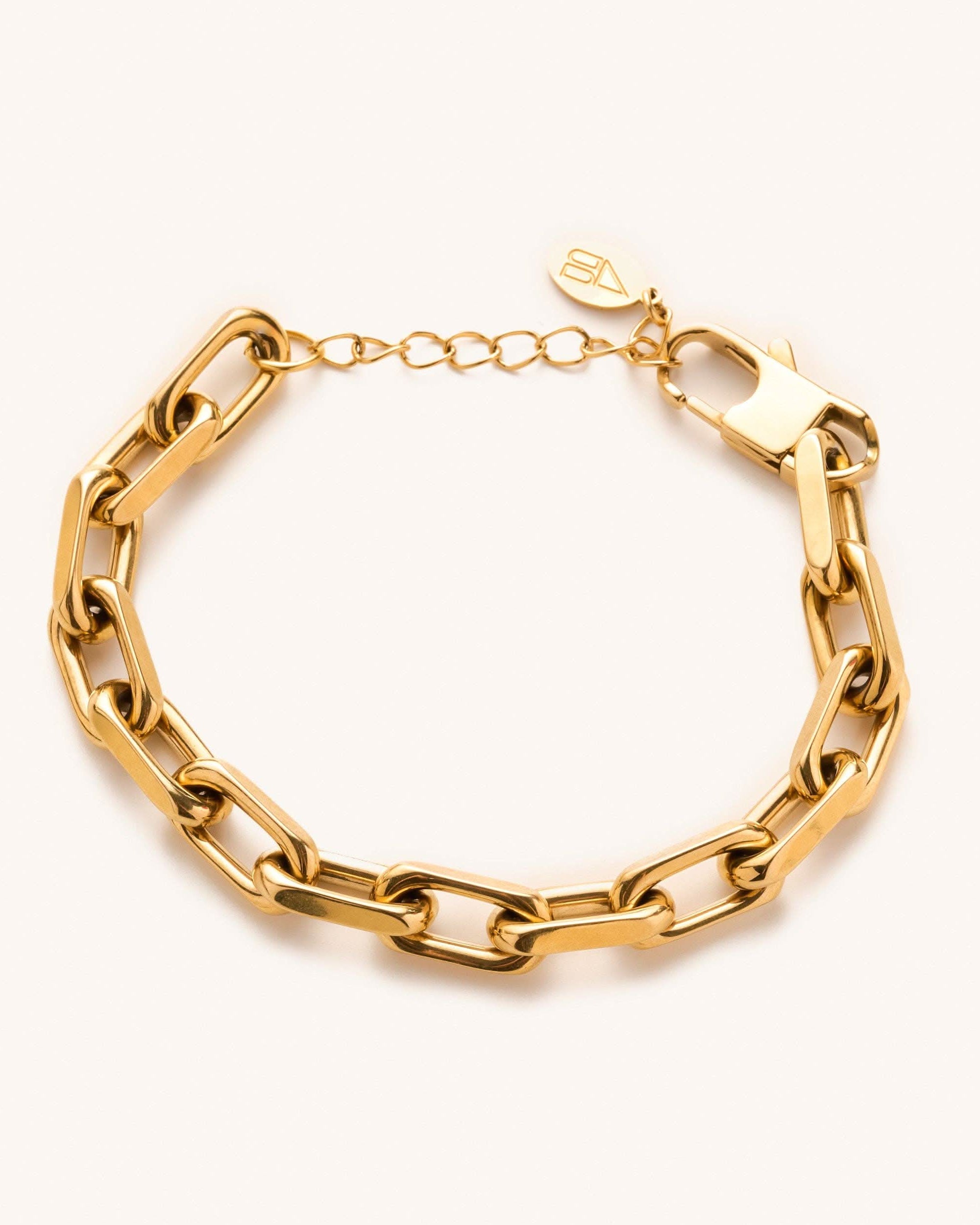 Gold, waterproof, chunky link bracelet from Nikki smith laying on a blank surface