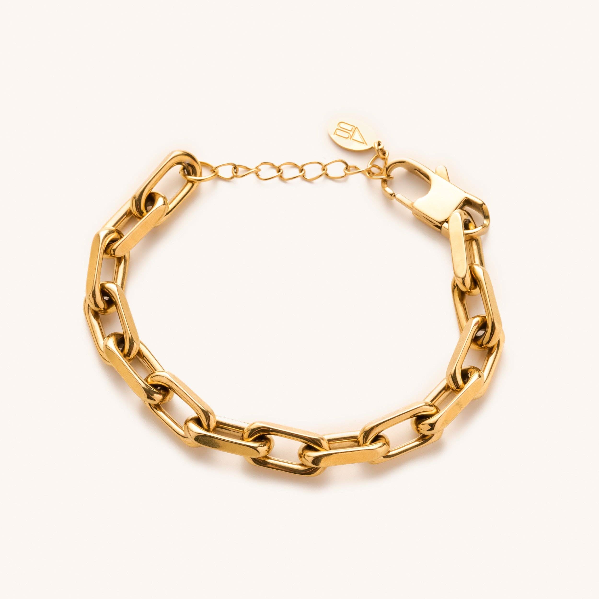 Gold, waterproof, chunky link bracelet from Nikki smith laying on a blank surface