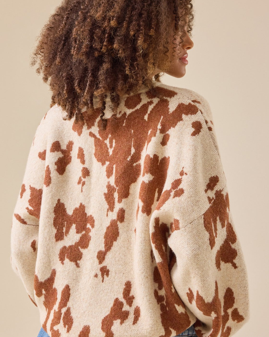 This statement knit features a bold cow print design that is sure to turn heads.