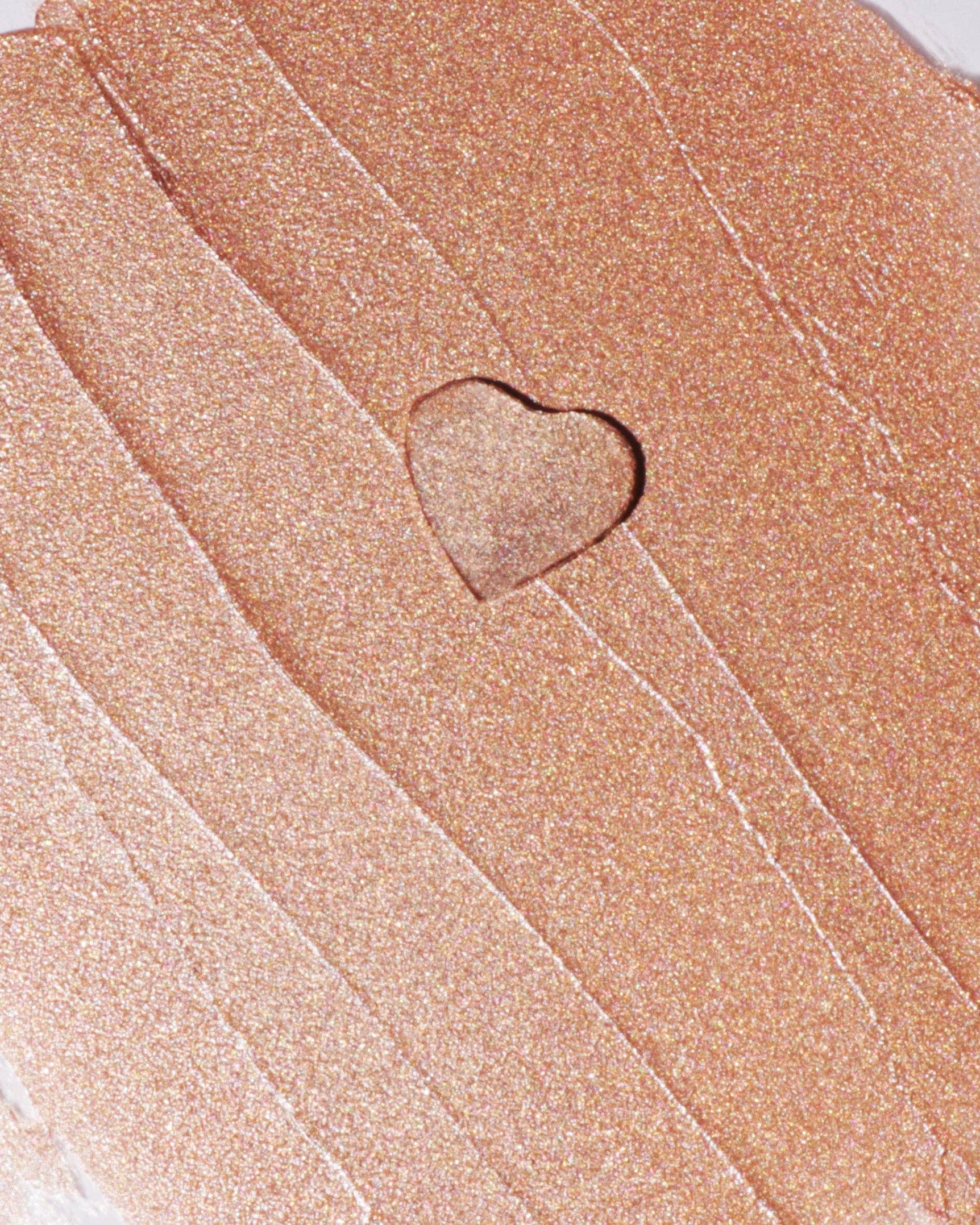 Close-up of a heart-shaped sand sculpture with a textured surface.
