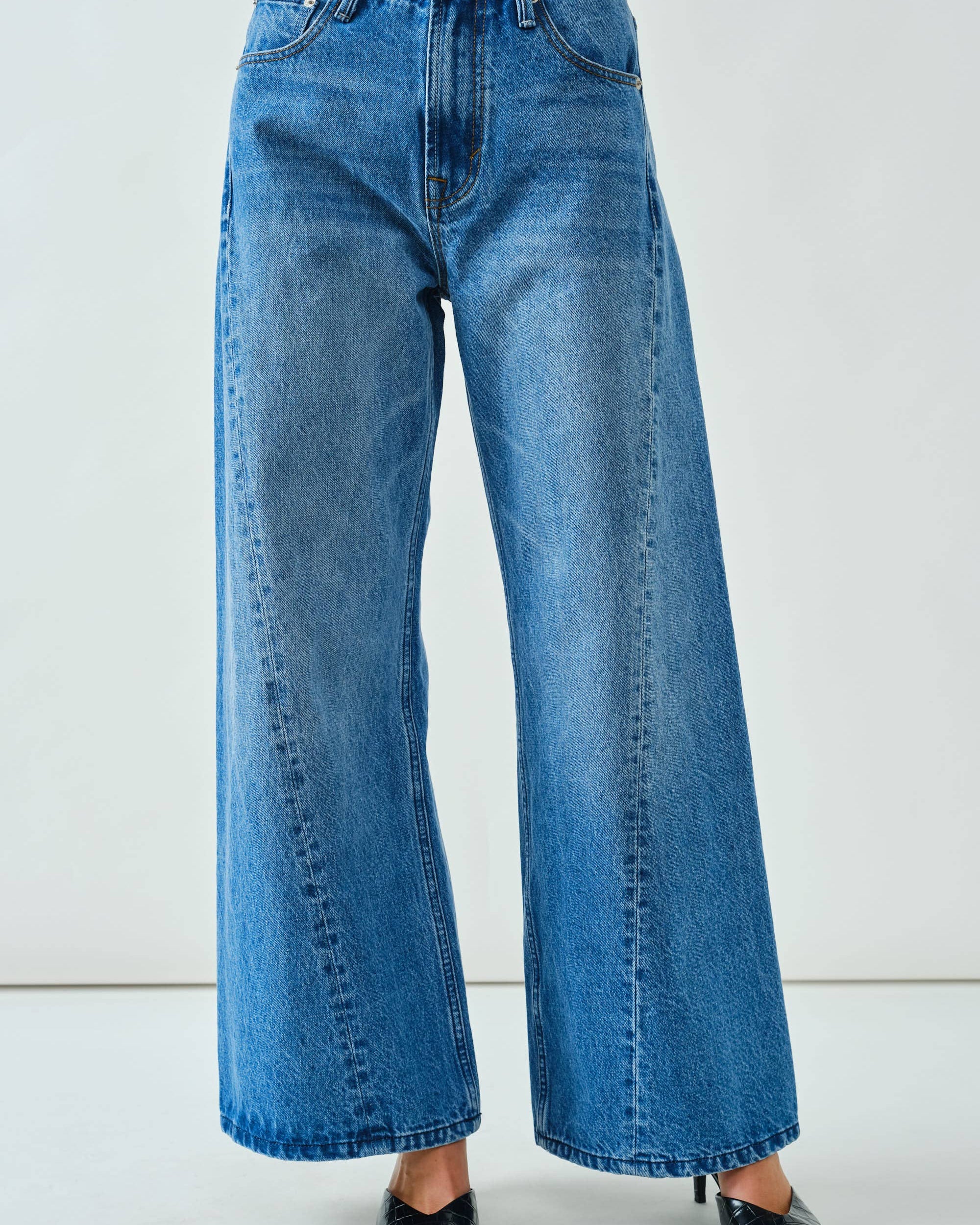 Blue jeans worn by a person on a white background