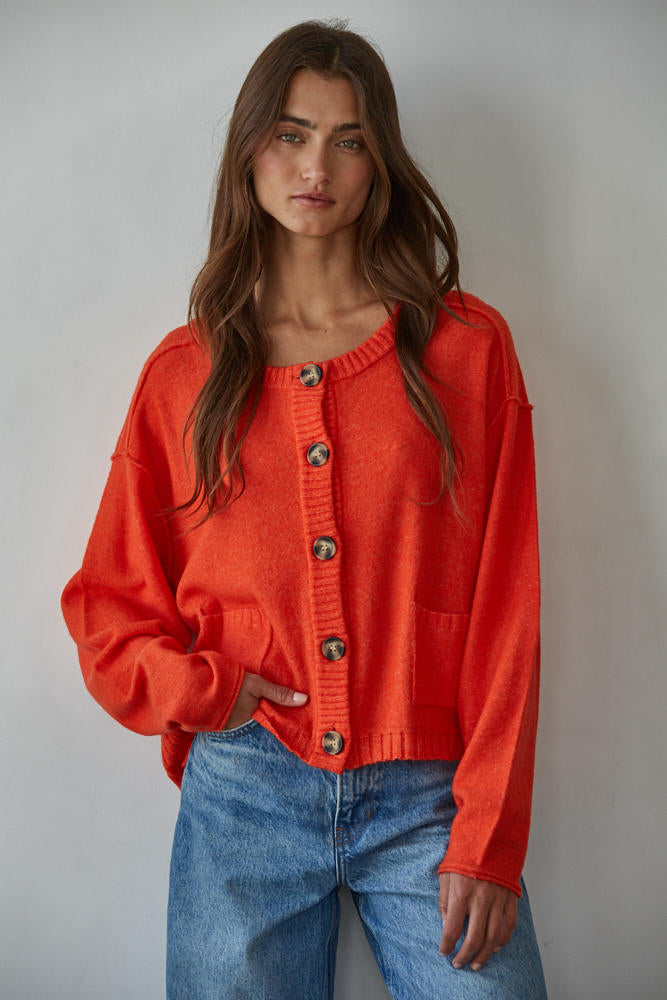 Woman wearing a bright orange cardigan