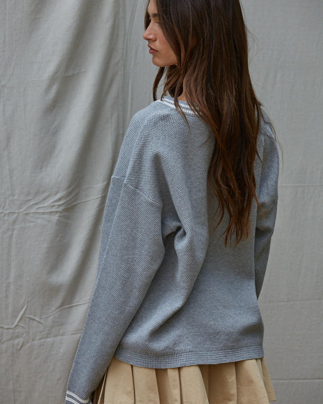 Woman wearing a light blue sweater and beige skirt