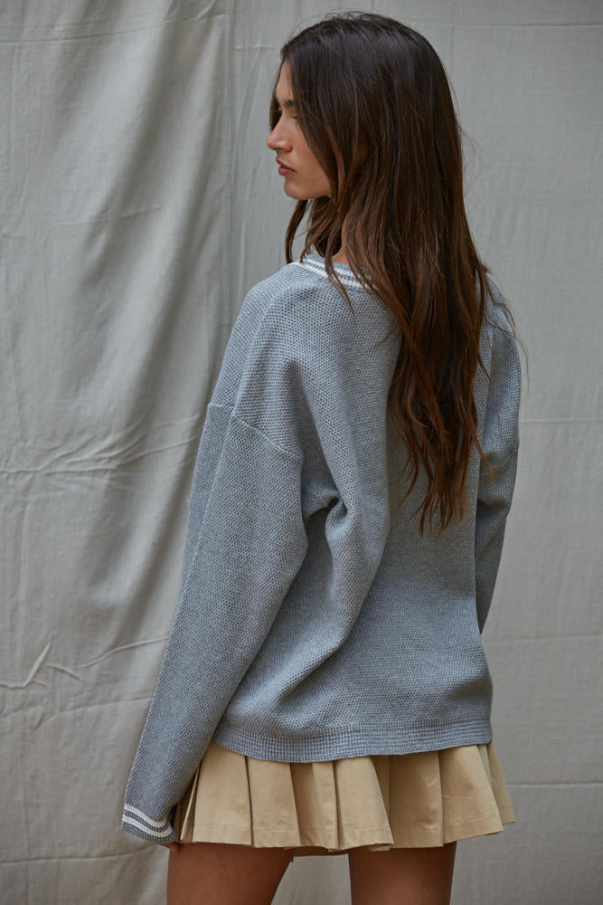 Woman wearing a light blue sweater and beige skirt