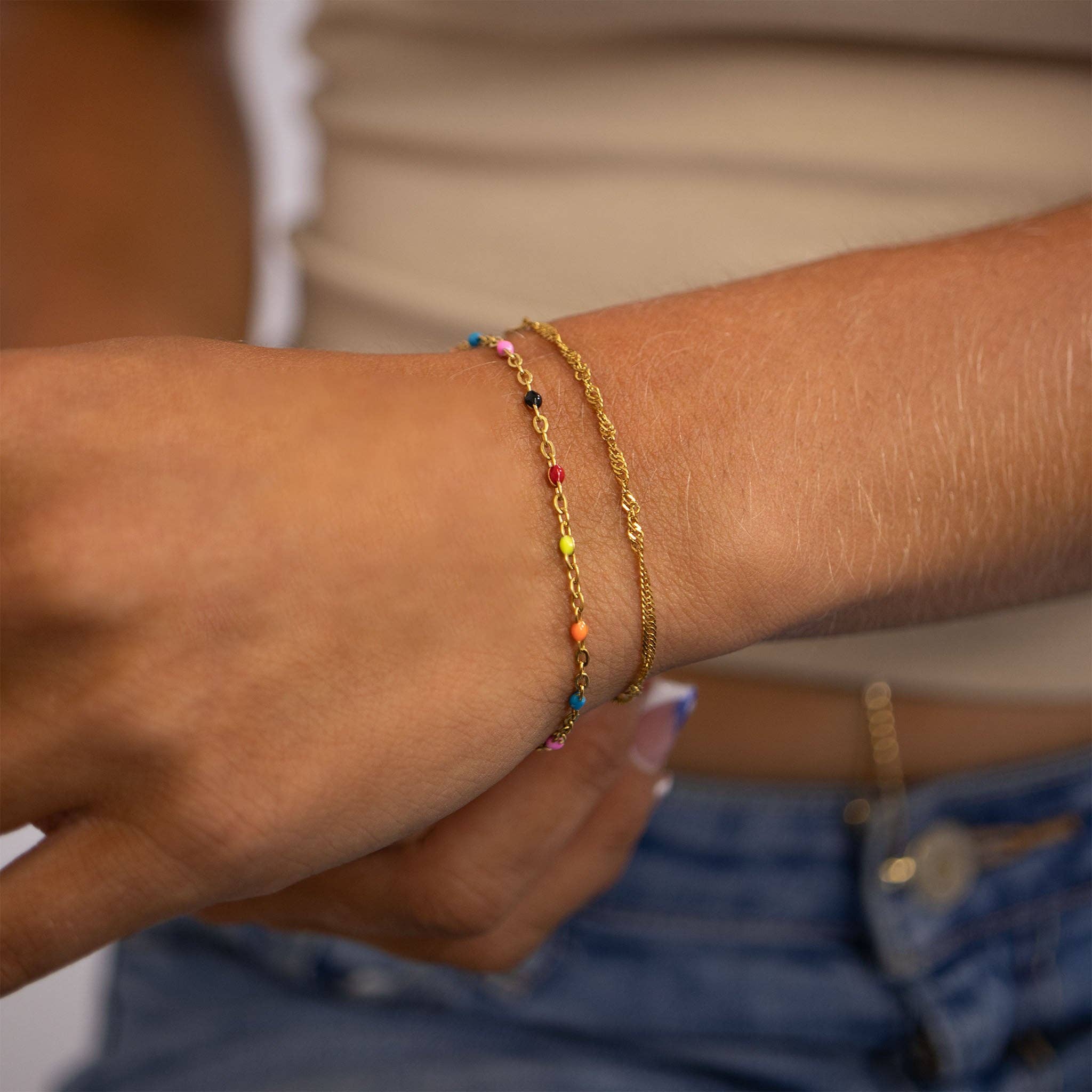 Close-up of a person's wrist wearing two bracelets with colorful beads.