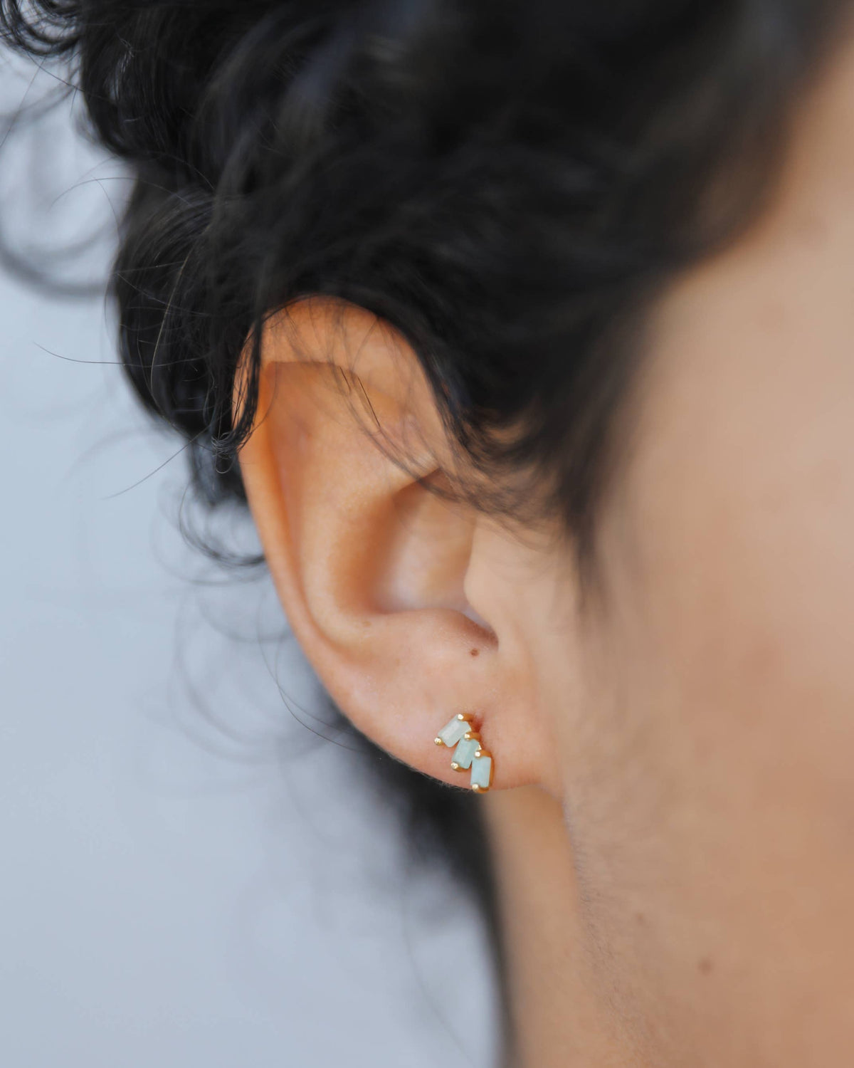 Close-up of an ear wearing a small earring with a blurred background