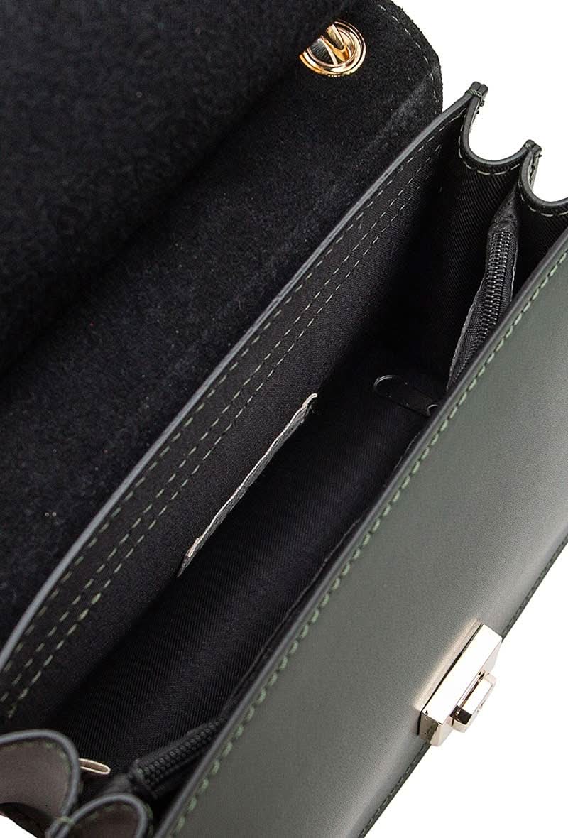 Inside view of Black leather handbag with gold details and clasp sitting against white background