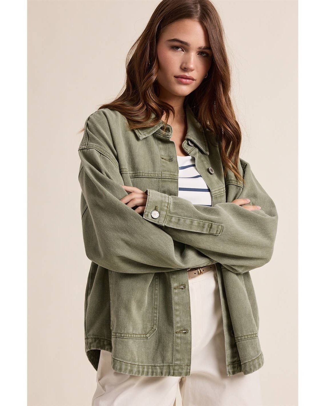 Woman wearing a green jacket with a neutral background
