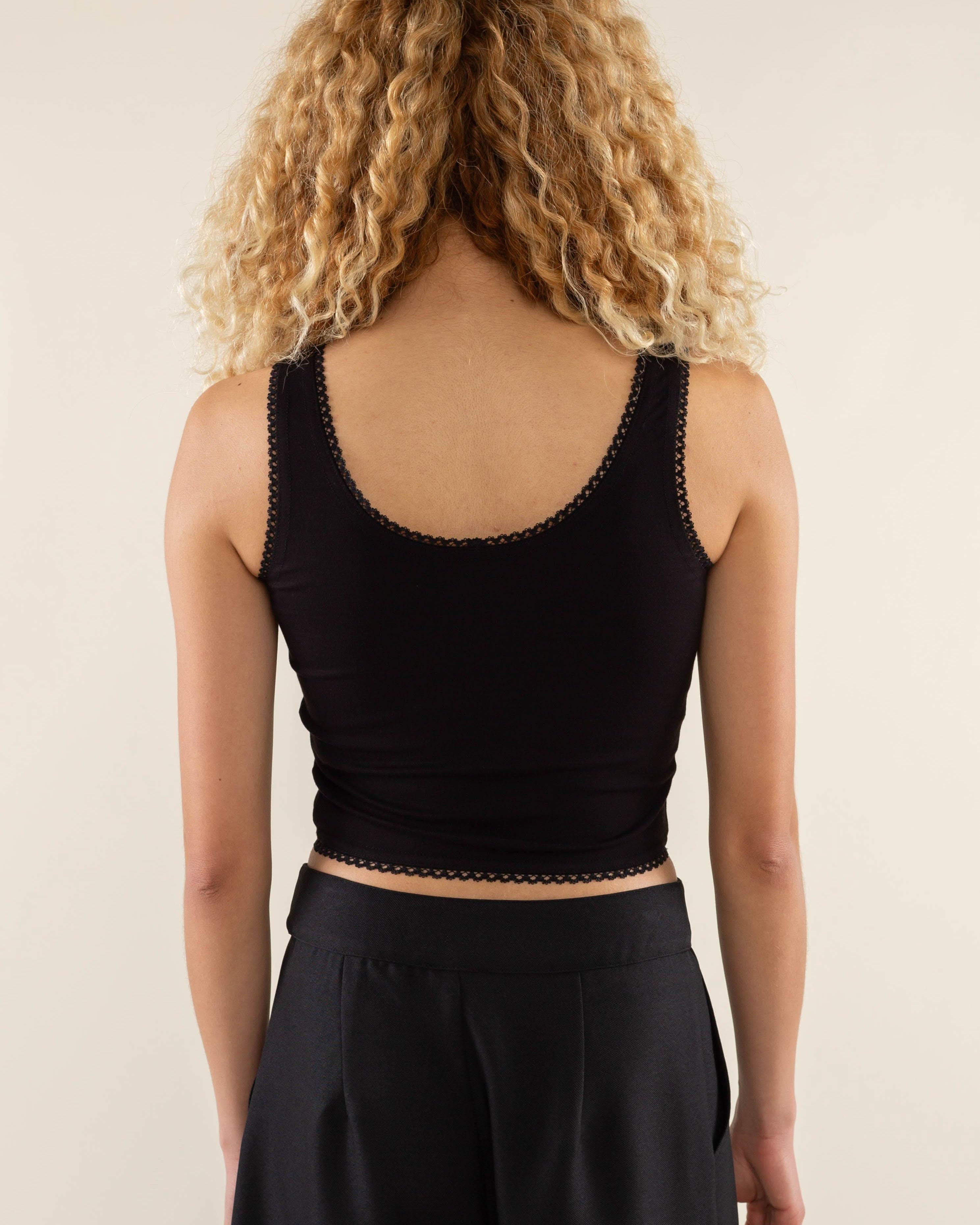 Woman wearing black, scallop trim, crop top with black jorts