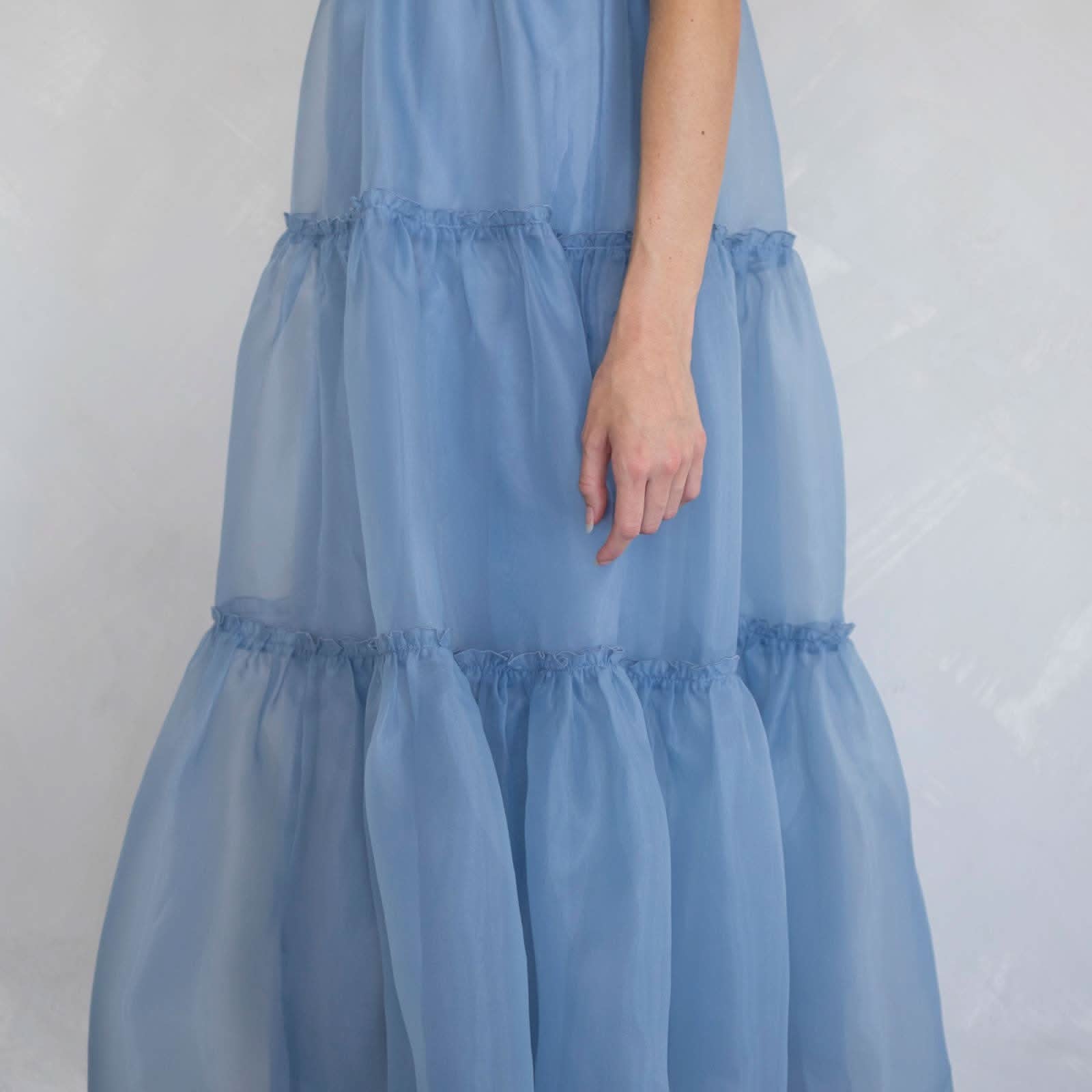 Light blue tiered dress worn by a person against a plain background