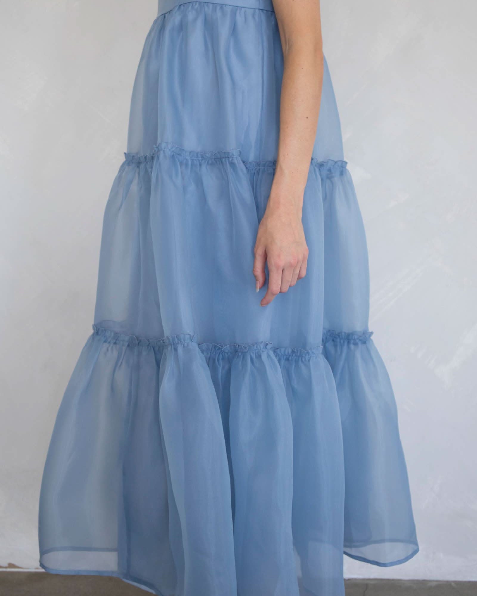 Light blue tiered dress worn by a person against a plain background