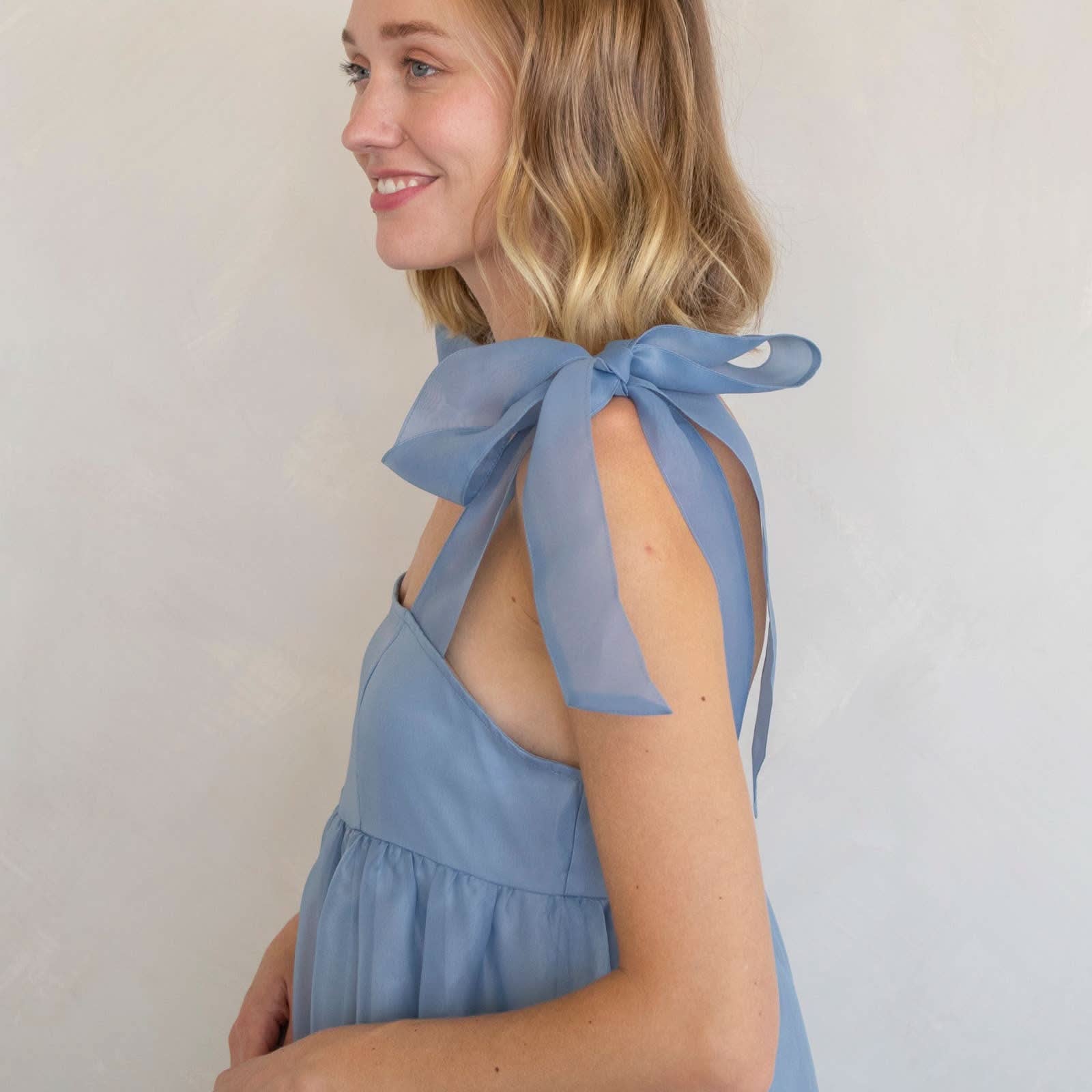 Woman wearing a light blue dress with bow straps